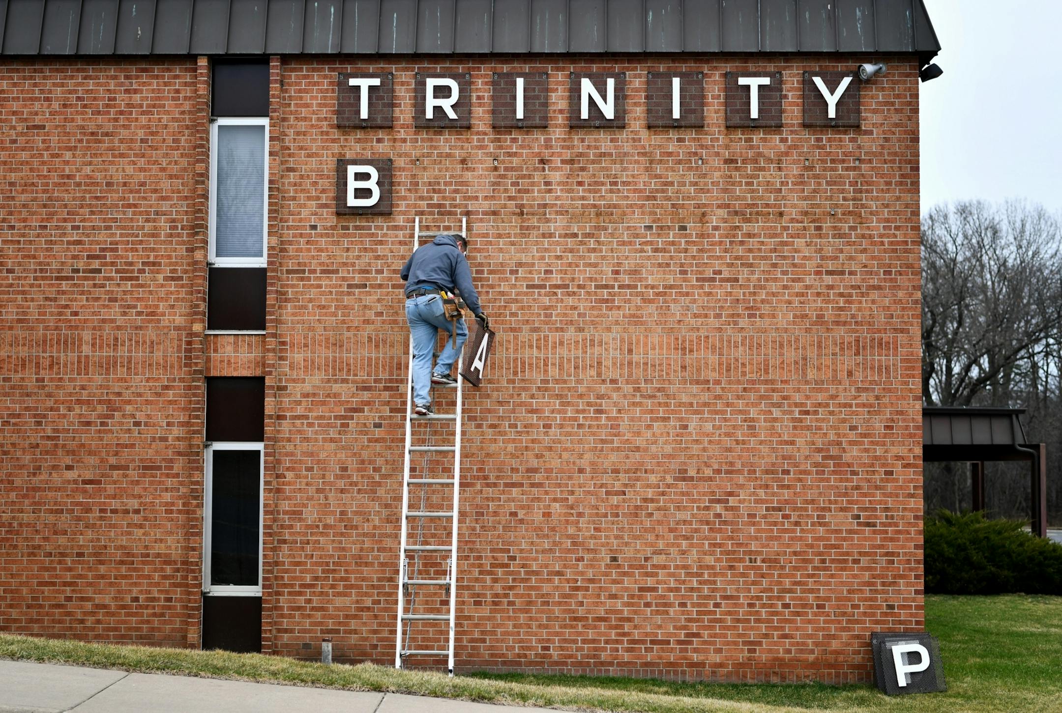Joe Stodola removed letters of the church's 50 year old sign. Trinity Baptist Church in Maplewood is about to become LifePoint Church.