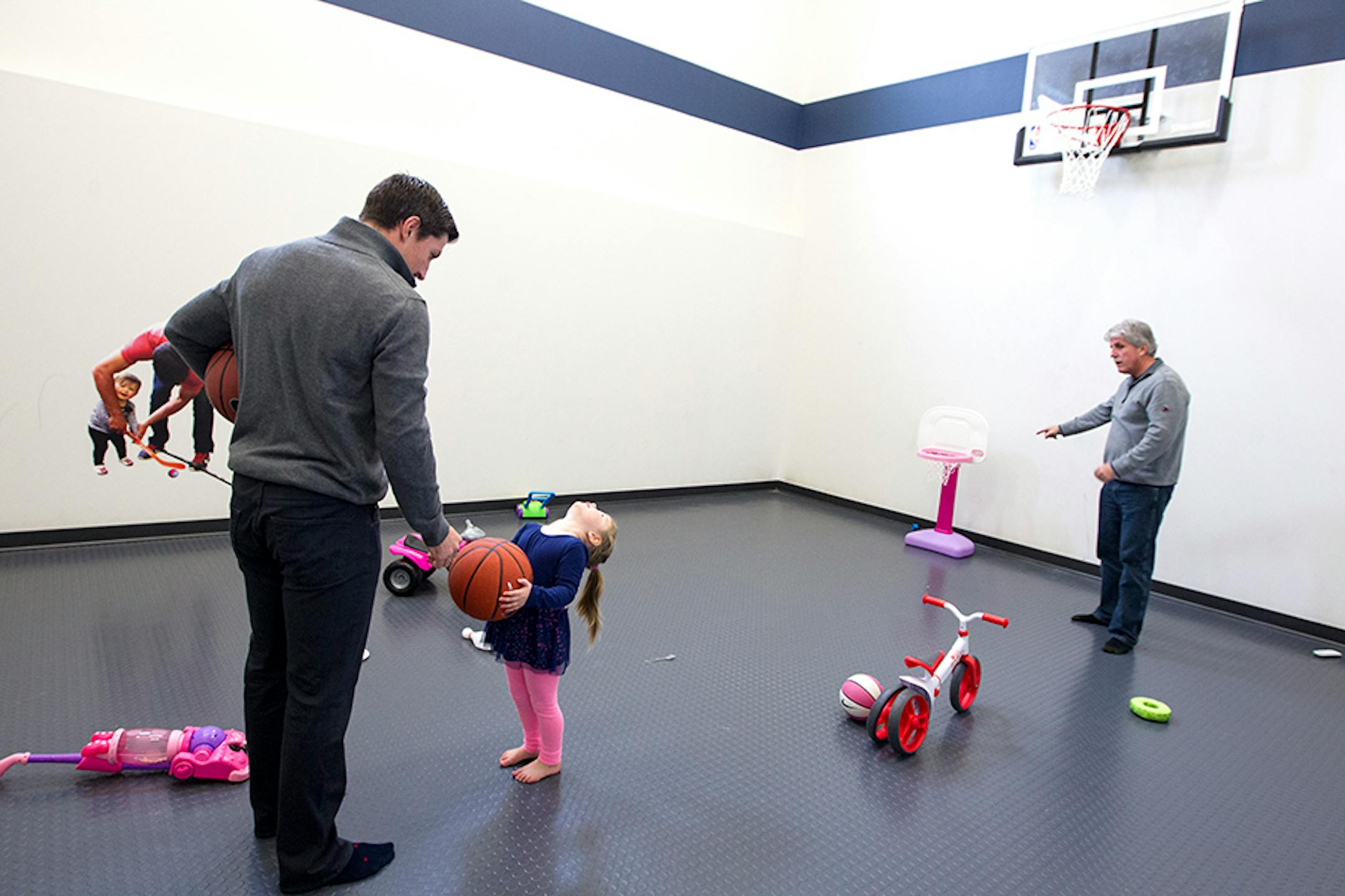 Minnesota Wild's Ryan Carter, left, and his dad, Mike Carter, help Ryan's daughter Maggie, 3, shoot a basketball at Ryan's home in Gem Lake November 22, 2015.