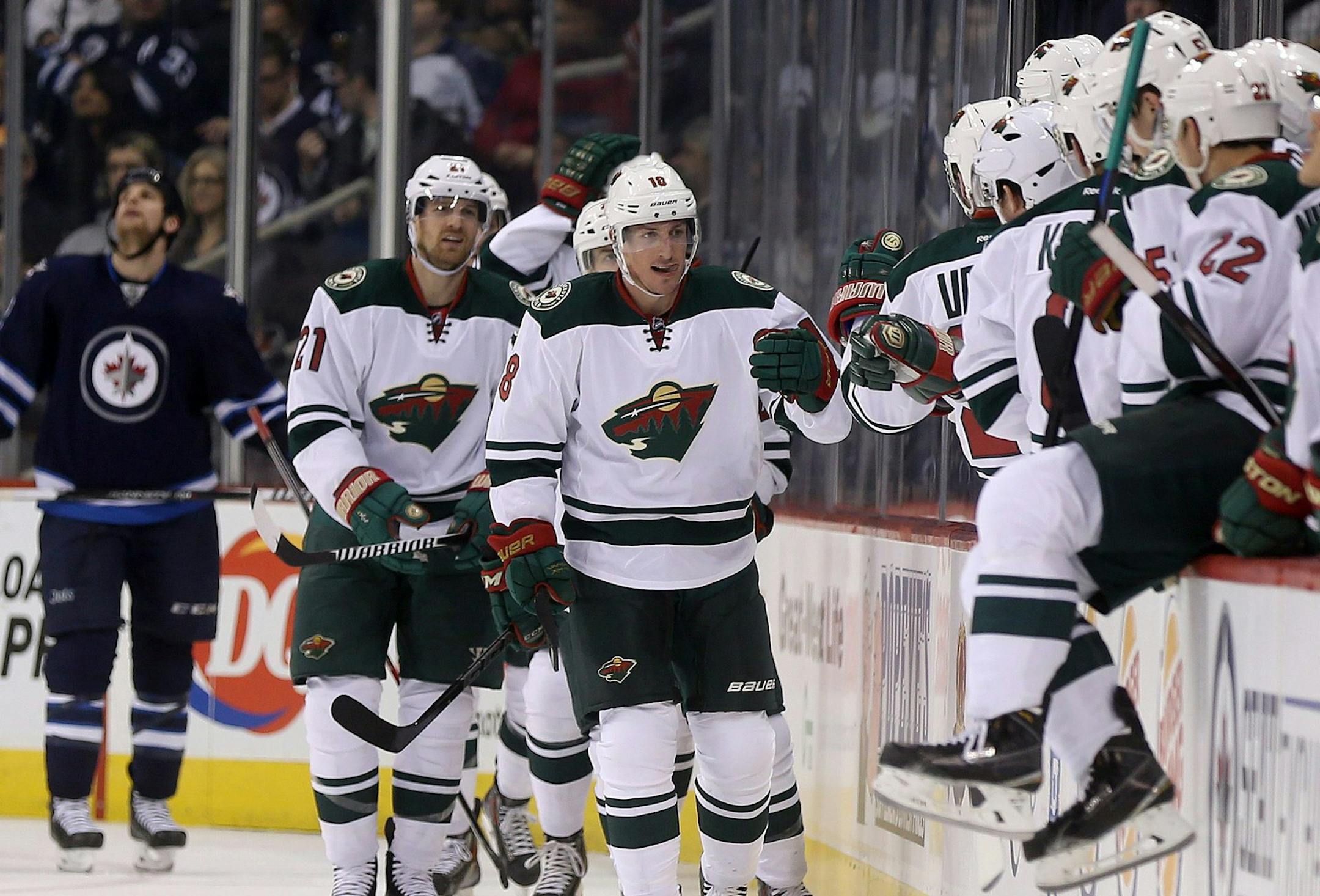 Minnesota Wild's Ryan Carter (18) celebrates after scoring against the Winnipeg Jets during the second period of an NHL hockey game in Winnipeg, Manitoba, Monday, Dec. 29, 2014. (AP Photo/The Canadian Press, Trevor Hagan)