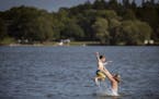 Willow Anderson throws up her son Henrik, 5, into the air in Lake Nokomis on the first day of autumn, Friday, Sept. 22, 2017 in Minneapolis, Minn. Hig