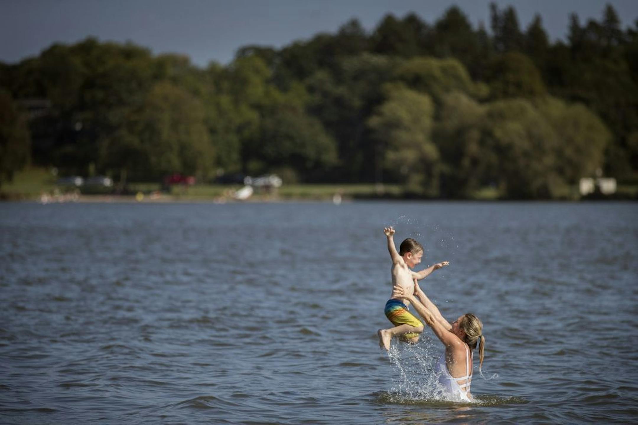 Willow Anderson throws up her son Henrik, 5, into the air in Lake Nokomis on the first day of autumn, Friday, Sept. 22, 2017 in Minneapolis, Minn. Highs were in the 90's, and the heat index reached 100 degrees.