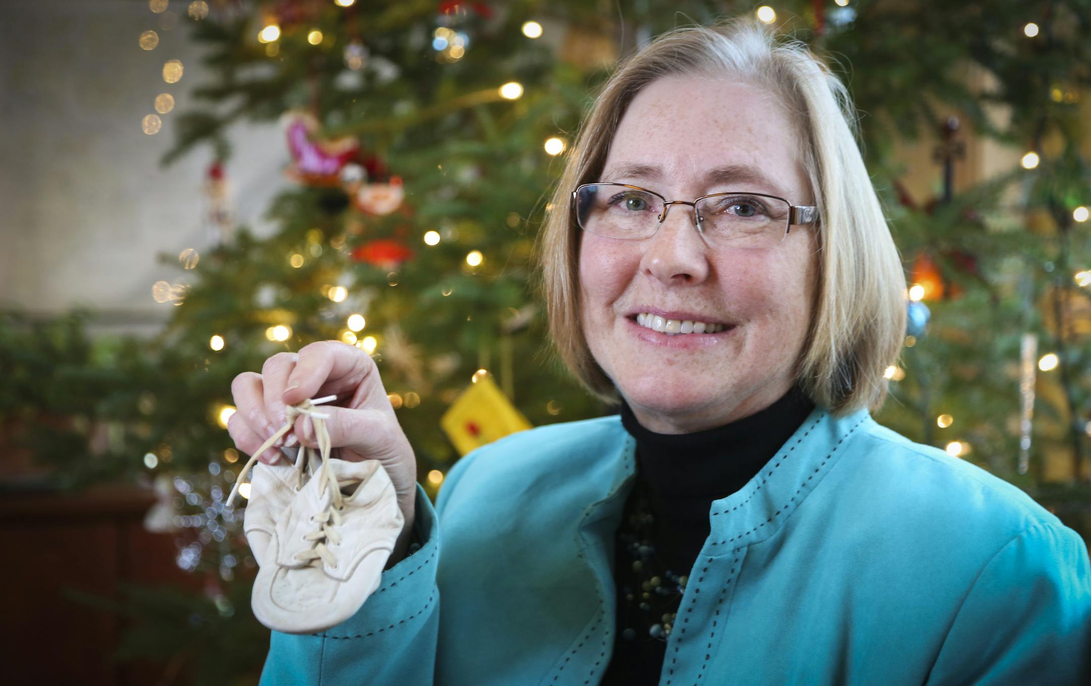 Deborah Jindra posed with her treasured ornament, her baby booties her mother found in her father's toolbox after he passed away, in Minnetrista, Minn., on Monday, December 16, 2014. ] REN√âE JONES SCHNEIDER reneejones@startribune.com