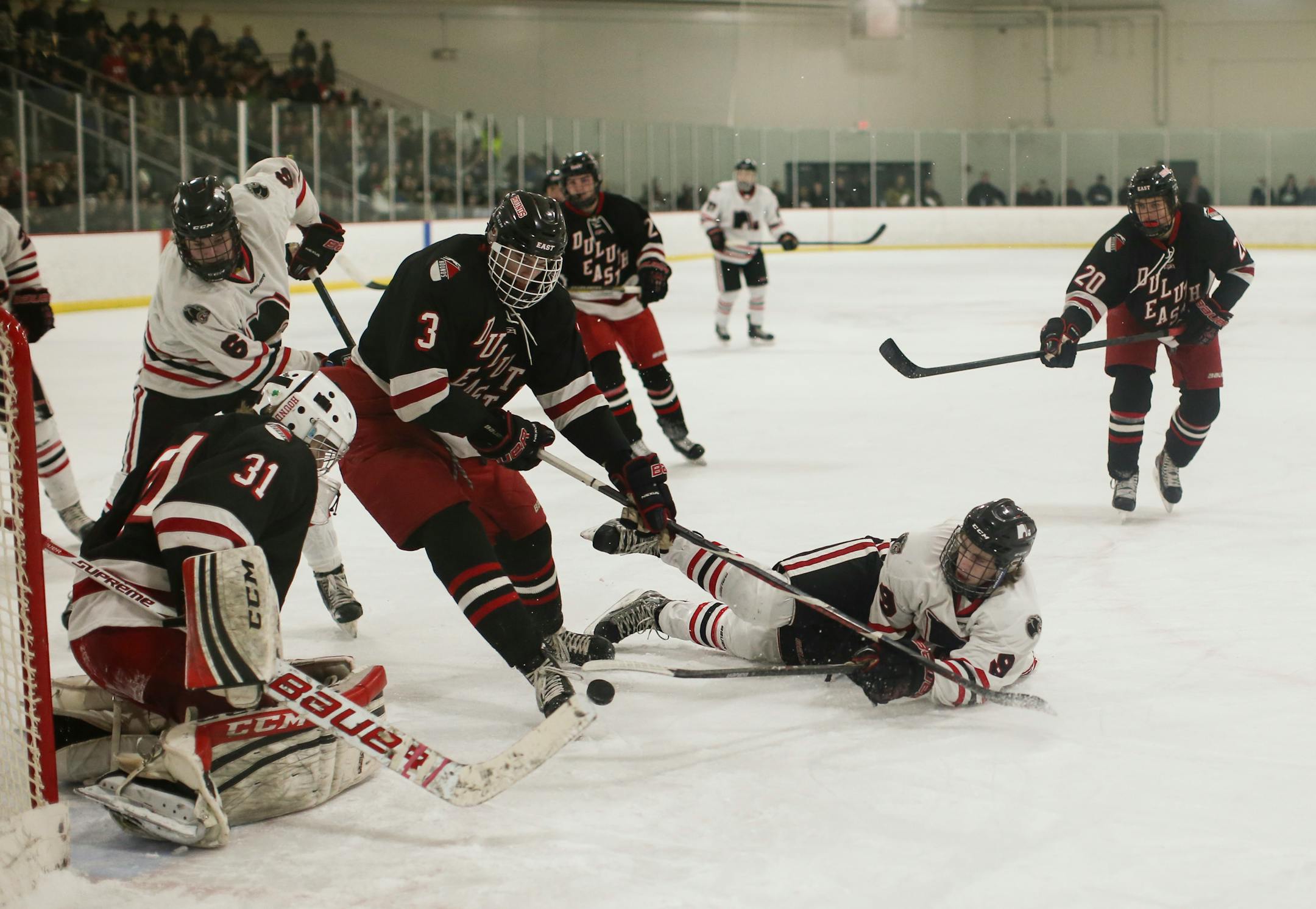 Lakeville North's Taylor Schneider tried to get his shot off after being knocked to the ice during a January victory over Duluth East. The Panthers are undefeated and ranked No. 1 as section play approaches.