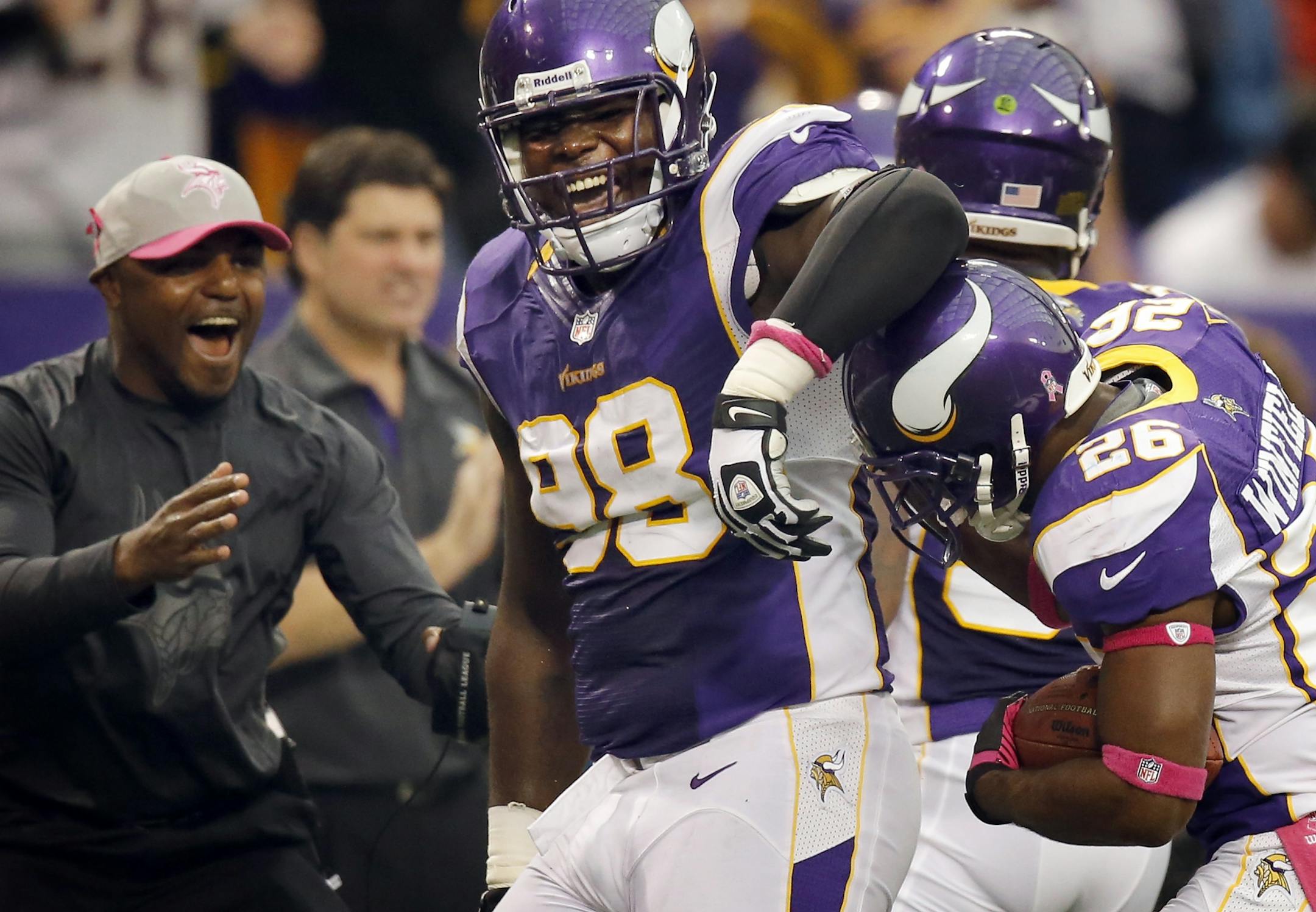 Letroy Guion (98) celebrated with Antoine Winfield (26) after his interception the second quarter.