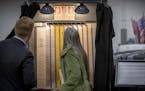 Visitors looked through a historical voting machine as they attended a ribbon cutting ceremony to open the new Elections & Voter Services, Friday, Oct