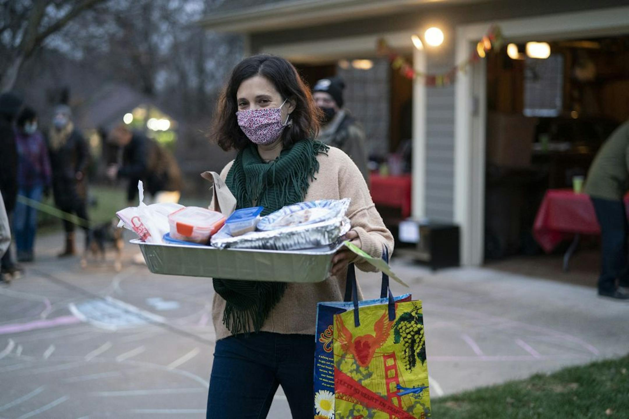 Amanda Harris carried her share of food to her car from the home of Av Gordon on Thanksgiving evening in Plymouth.