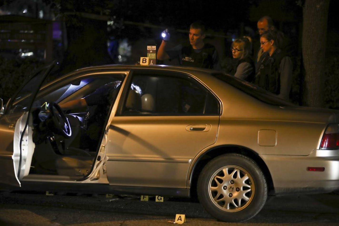 Investigators from the Minneapolis Police Department crime lab placed markers on evidence in the car where a stabbing took place in Dinkytown Thursday night.