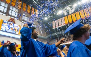 Wynton Haulcy prepare to throw his cap in the air while confetti fires at the conclusion of the Hopkins High School graduation ceremony Tuesday, June
