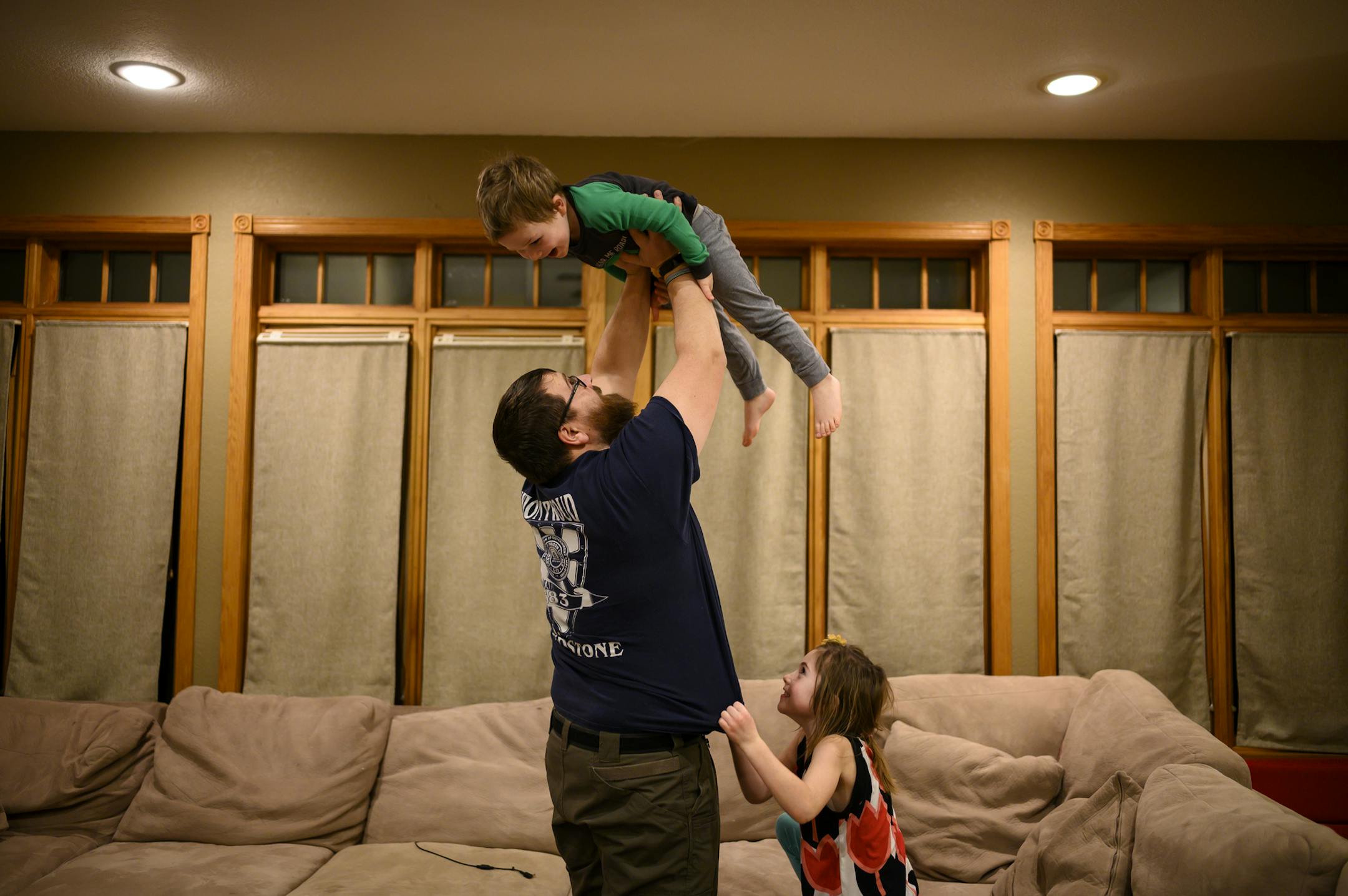 Steve Denzine, who has been working without pay at the Sandstone prison, played with his two children, Robbie, 3, and Stella, 6, after reading time in the living room Jan. 16.
