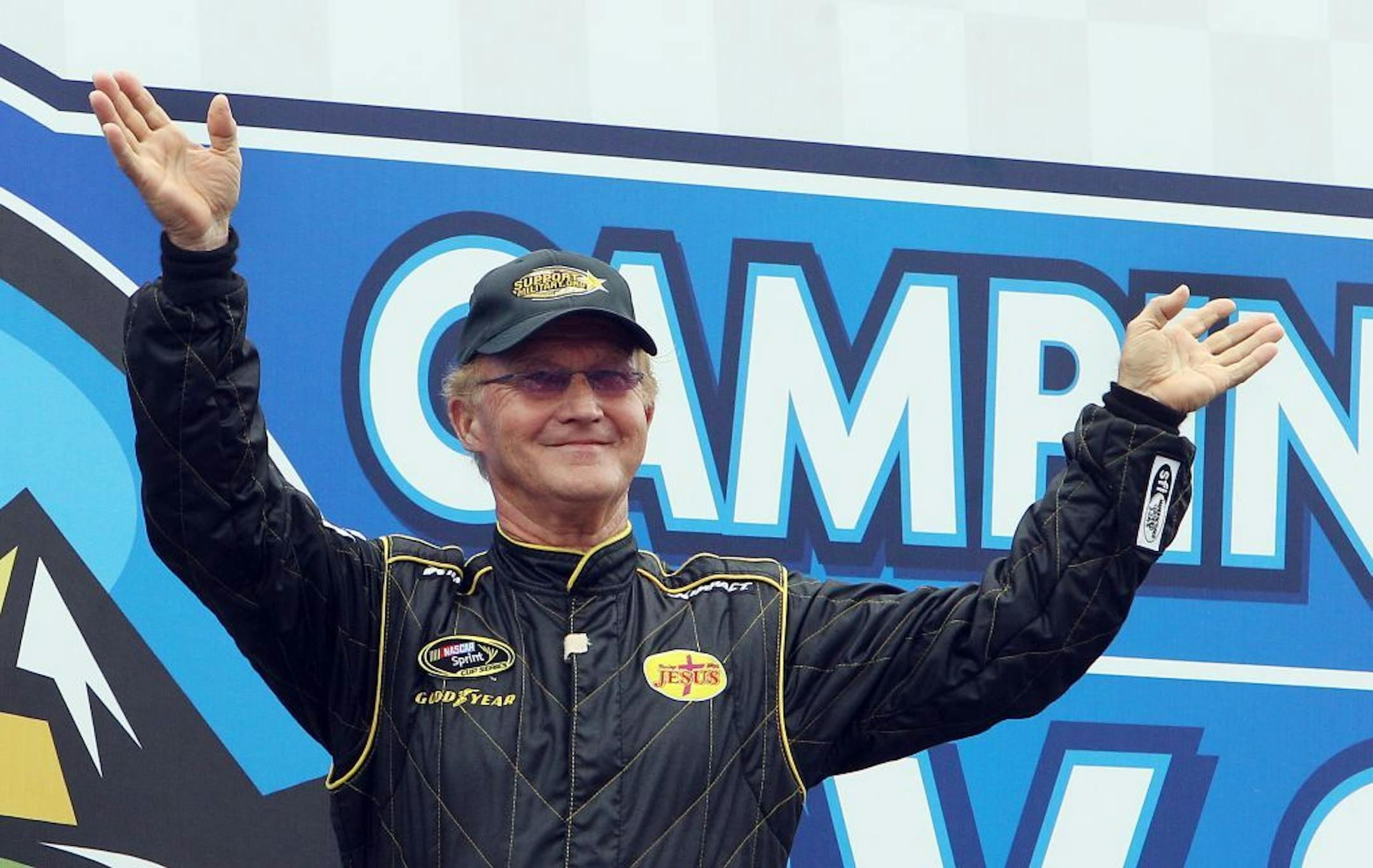 Morgan Shepherd waves to cheering fans as he is introduced for the NASCAR Sprint Cup series auto race at New Hampshire Motor Speedway, Sunday, July 14, 2013 in Loudon, N.H. Shepherd, 71, is the older driver to start a race in the series.