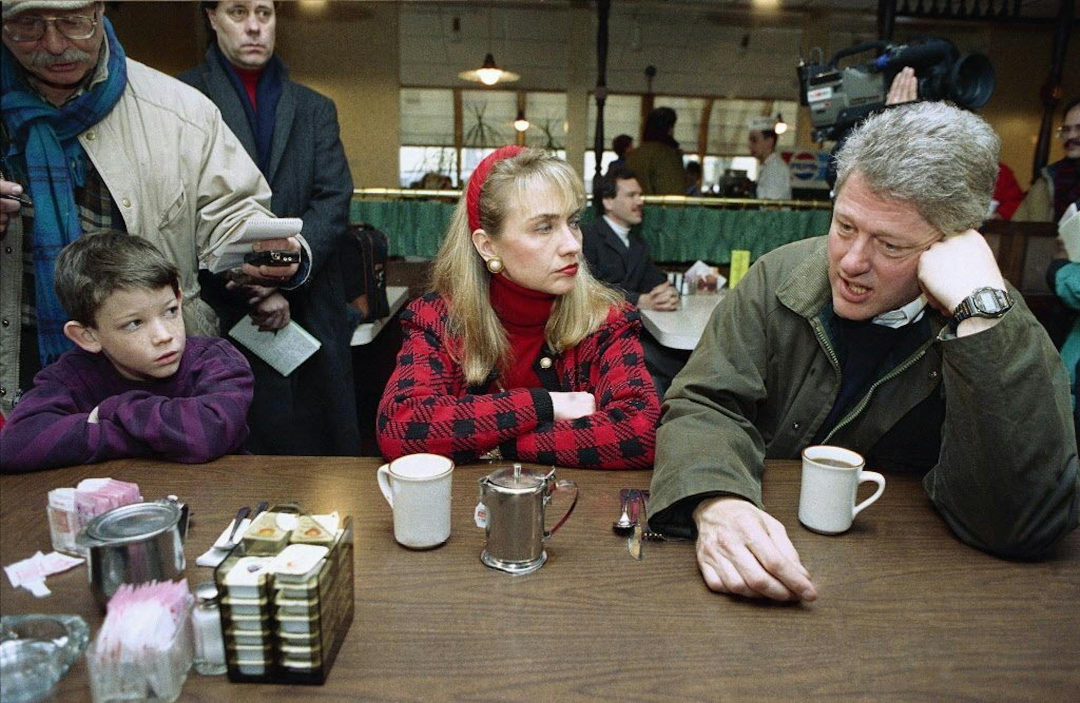 FILE - In this Feb. 15, 1992 file photo, Andrew Dodwell listen as left, as Democratic presidential candidate, Arkansas Gov. Bill Clinton, accompanied by his wife Hillary Clinton stop at a restaurant in Manchester, N.H. for a cup of coffee prior to a door-to-door campaign drive. For nearly 25 years, New Hampshire has been the backdrop for some of the most memorable Clinton comebacks, pleas, denials, hustle, glory and drama. Now those ghosts of primaries past are trailing Hillary Clinton as she tr