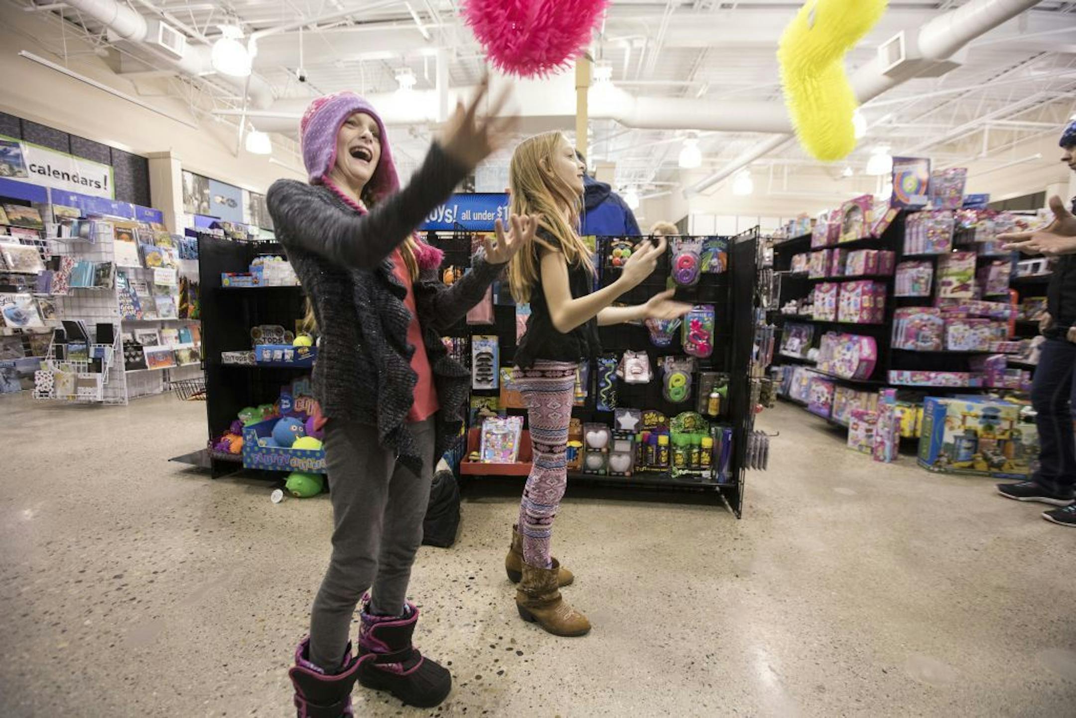 Isabelle, left, and Abby Carlsen play at a toy store while Christmas shopping with their parents at Kirkland Mall in Bismarck.
