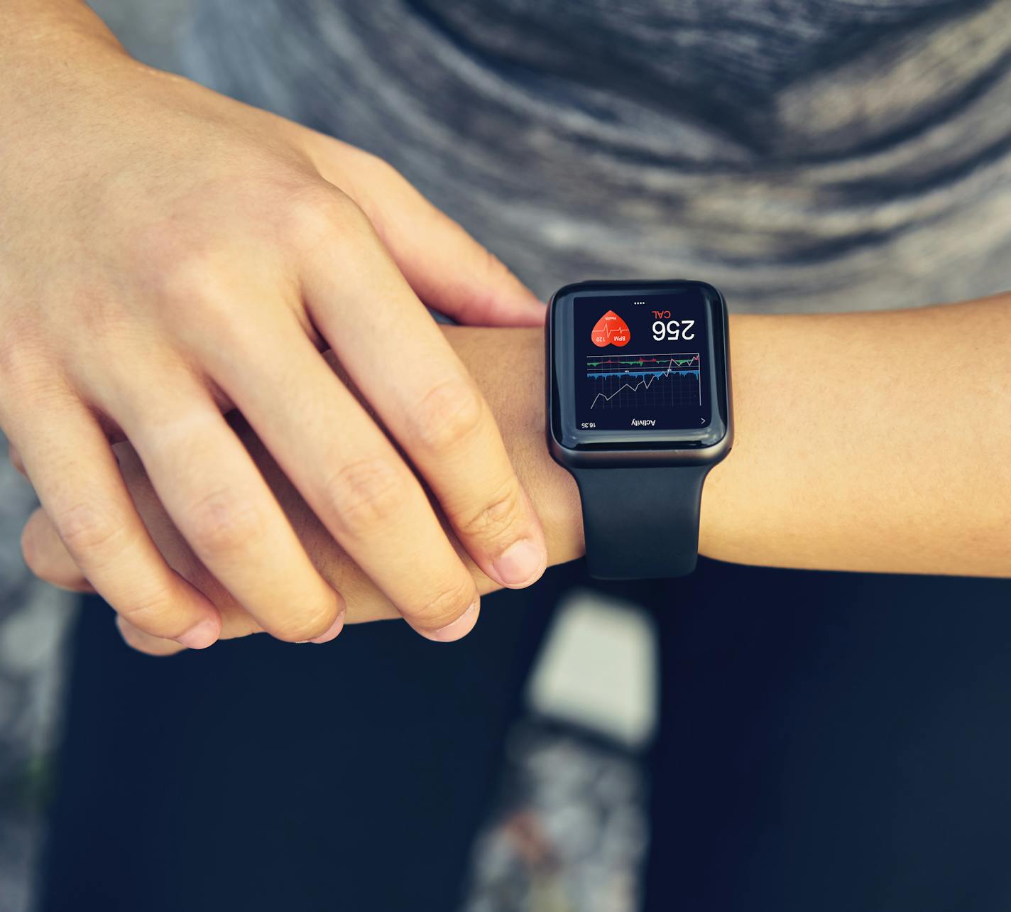 Young woman checking the sports watch measuring heart rate and performance after running.