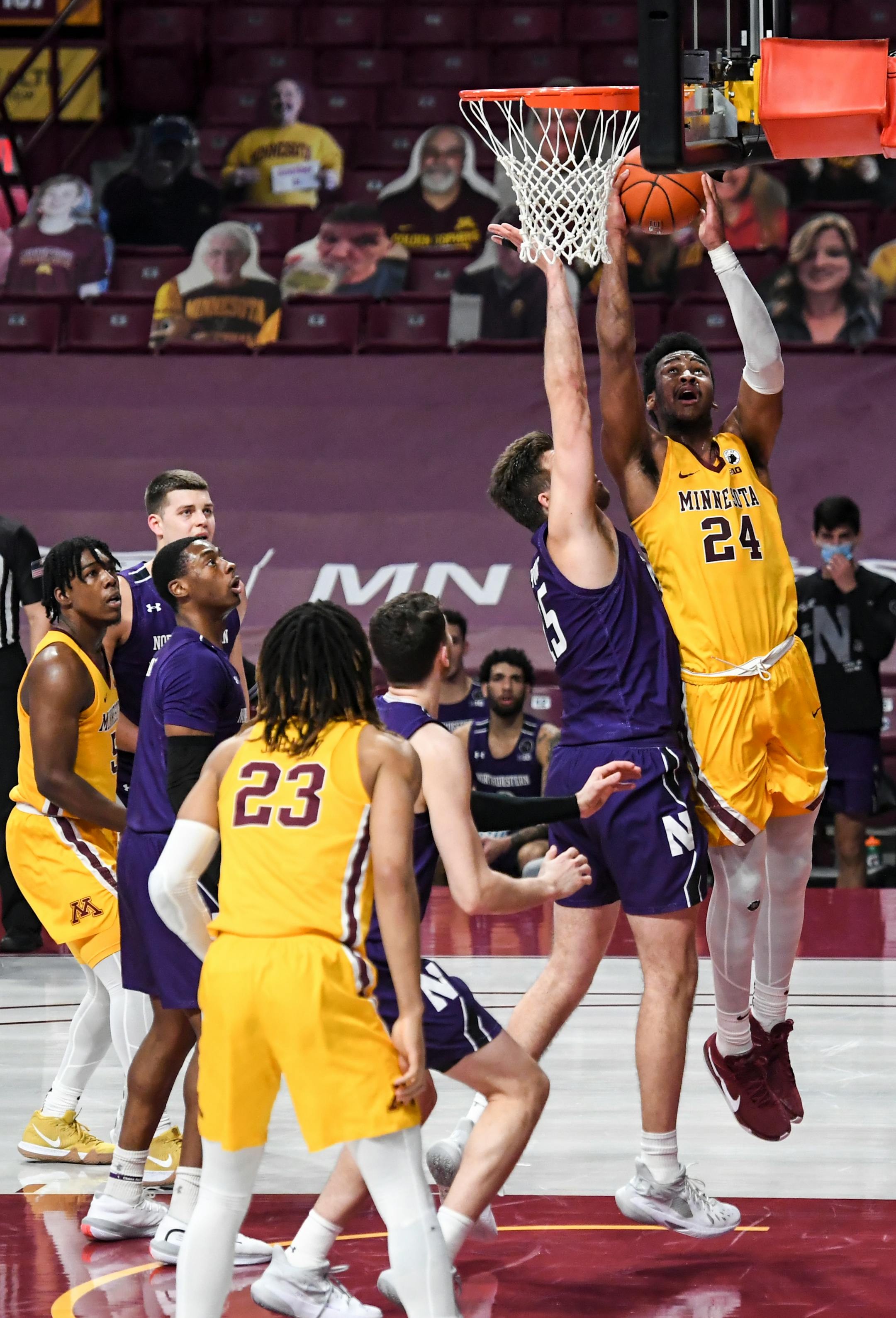 Minnesota Gophers forward Eric Curry (24) scored in the paint as he was defended by Northwestern Wildcats center Ryan Young (15) in the first half.