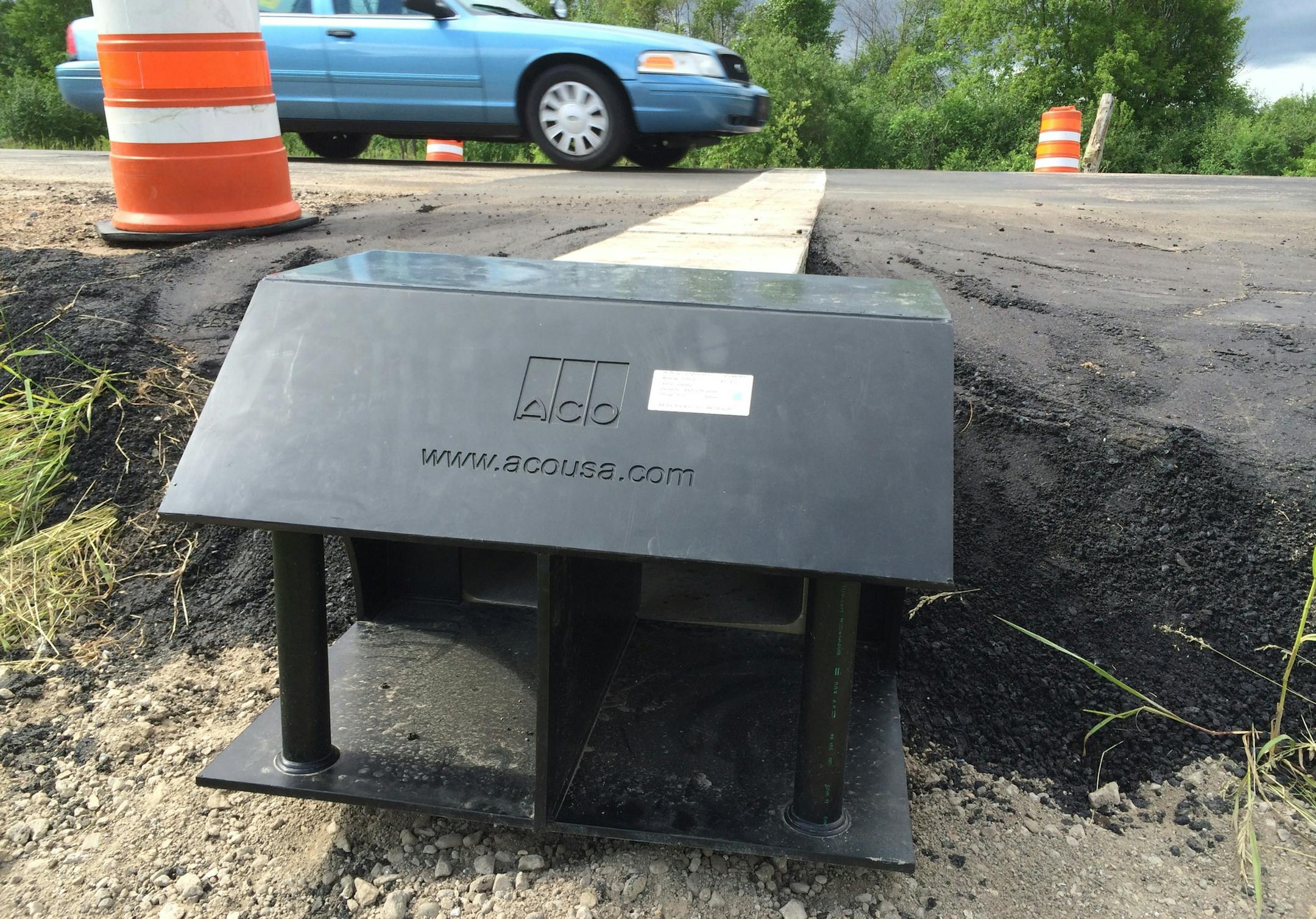 A car drives across the "turtle tunnel" 170th Street in May Township, which officials hope will allow Blanding's turtles to make their way to and from wetlands on either side of the road.