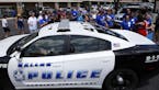 A Dallas police car drives by a fundraising event for officer Michael Smith, Sunday, July 10, 2016, in Farmers Branch, Texas. Smith was one of five of
