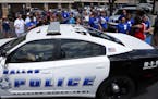 A Dallas police car drives by a fundraising event for officer Michael Smith, Sunday, July 10, 2016, in Farmers Branch, Texas. Smith was one of five of
