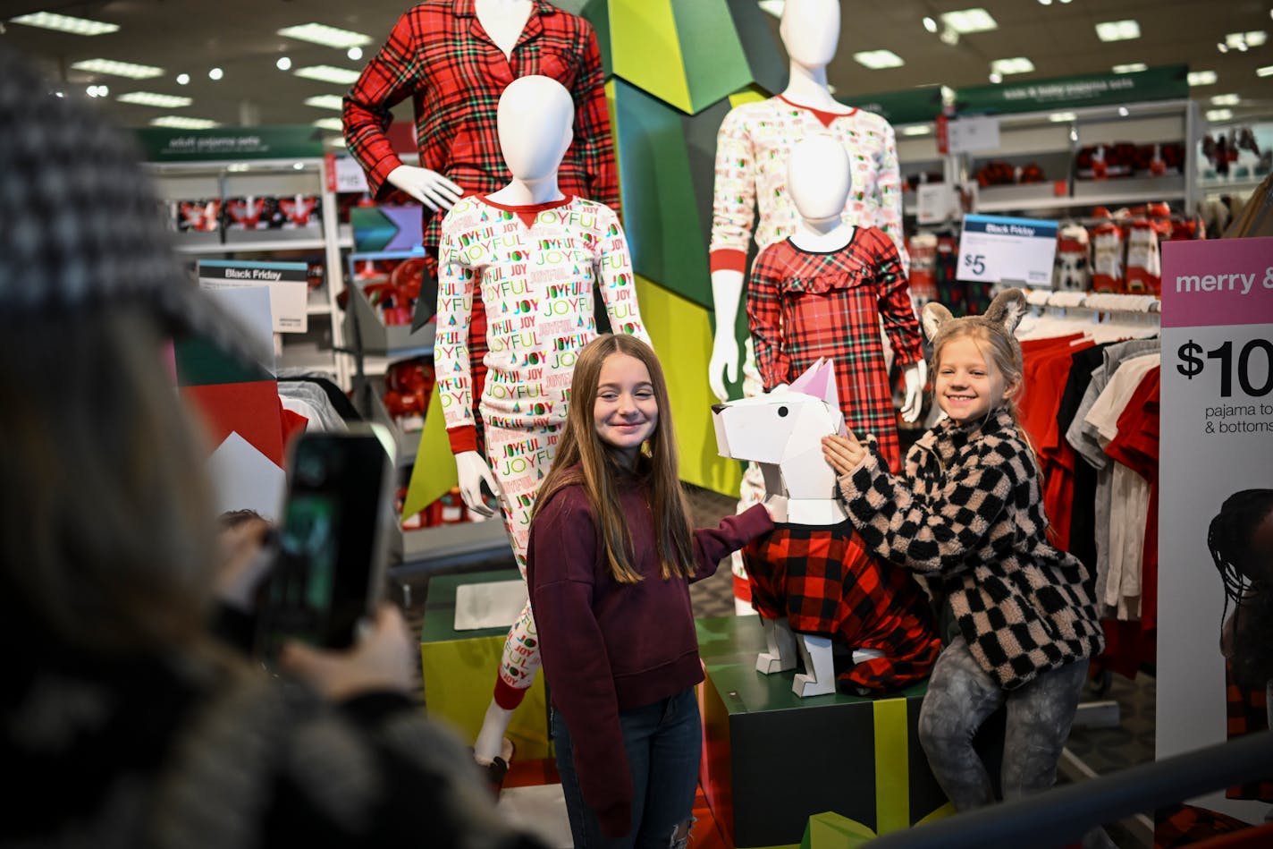 Nicole Leary of Edina took a photo of her daughter Sloane, right, and niece Teagan Swanson as they posed with a mannequin of Target mascot Bullseye during Black Friday shopping in 2022 in Edina.