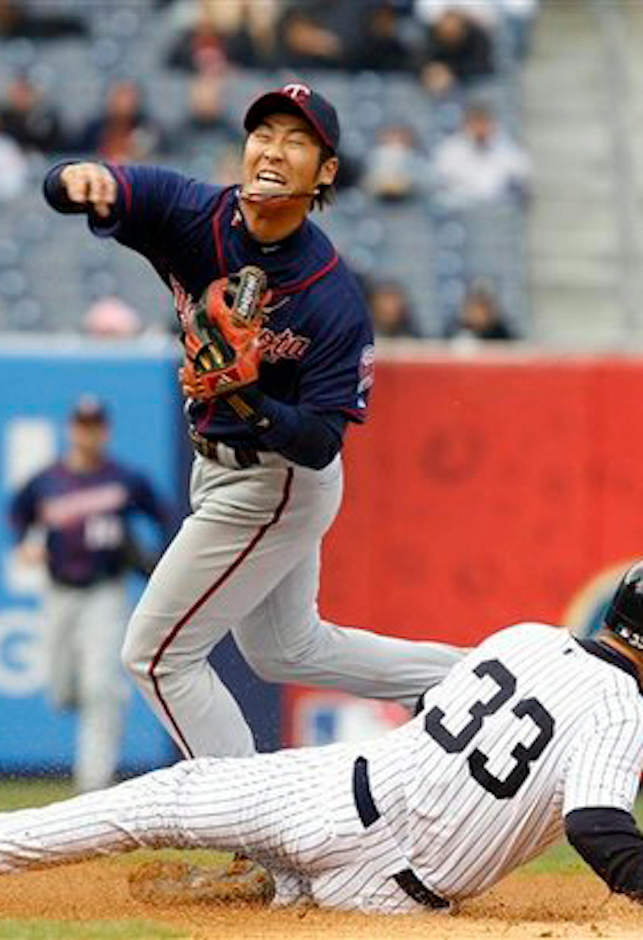 Minnesota Twins second baseman Tsuyoshi Nishioka (1) is injured he forces out New York Yankees Nick Swisher (33) when Mark Teixeira grounded into a fielder's choice in the seventh inning of their baseball game at Yankee Stadium in New York, Thursday, April 7, 2011. Nioshoika was taken out of the game after the play. (AP Photo/Kathy Willens)