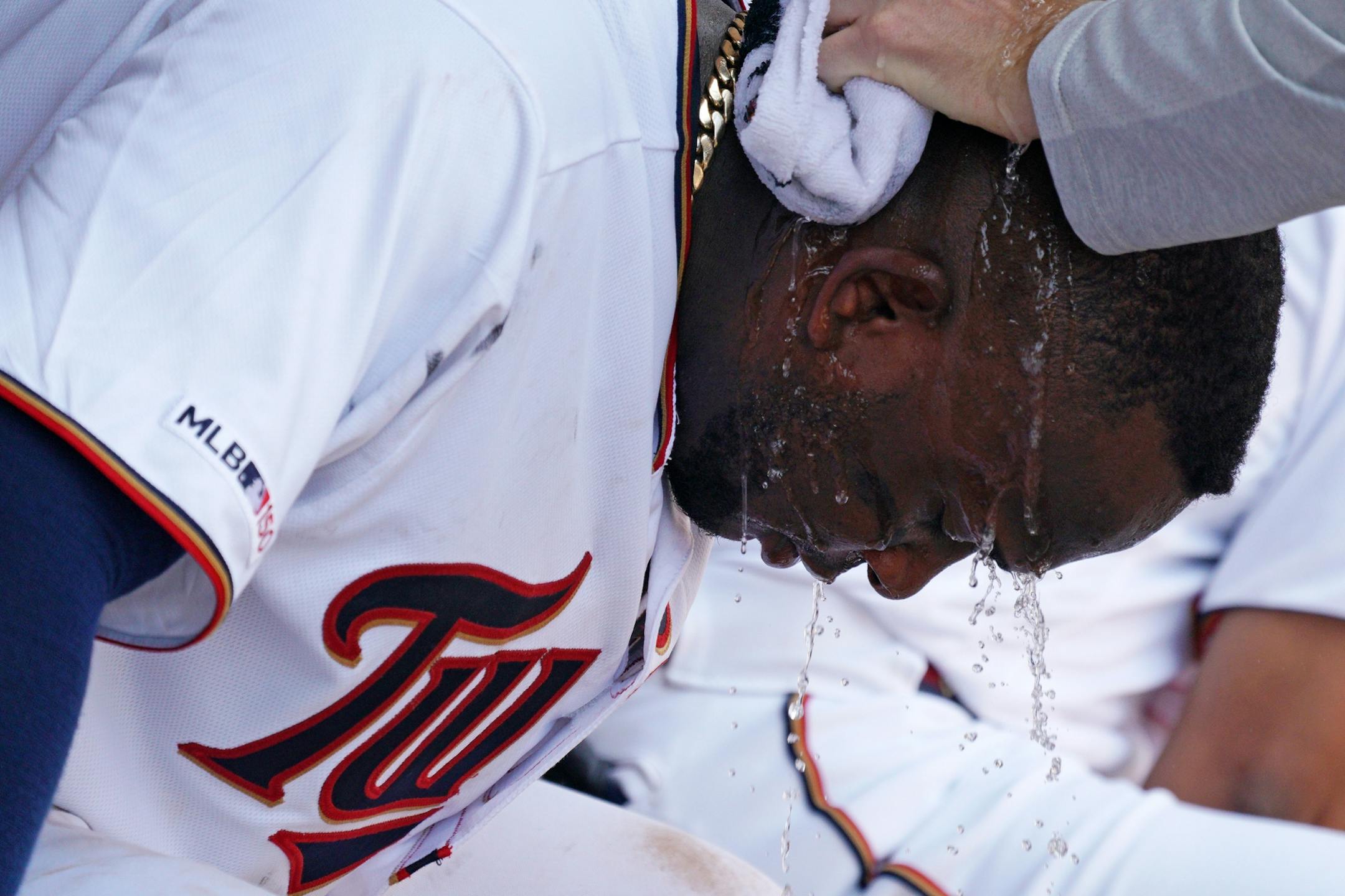 Minnesota Twins third baseman Miguel Sano (22) got a wet towel poured over his head by a trainer in the sixth inning.