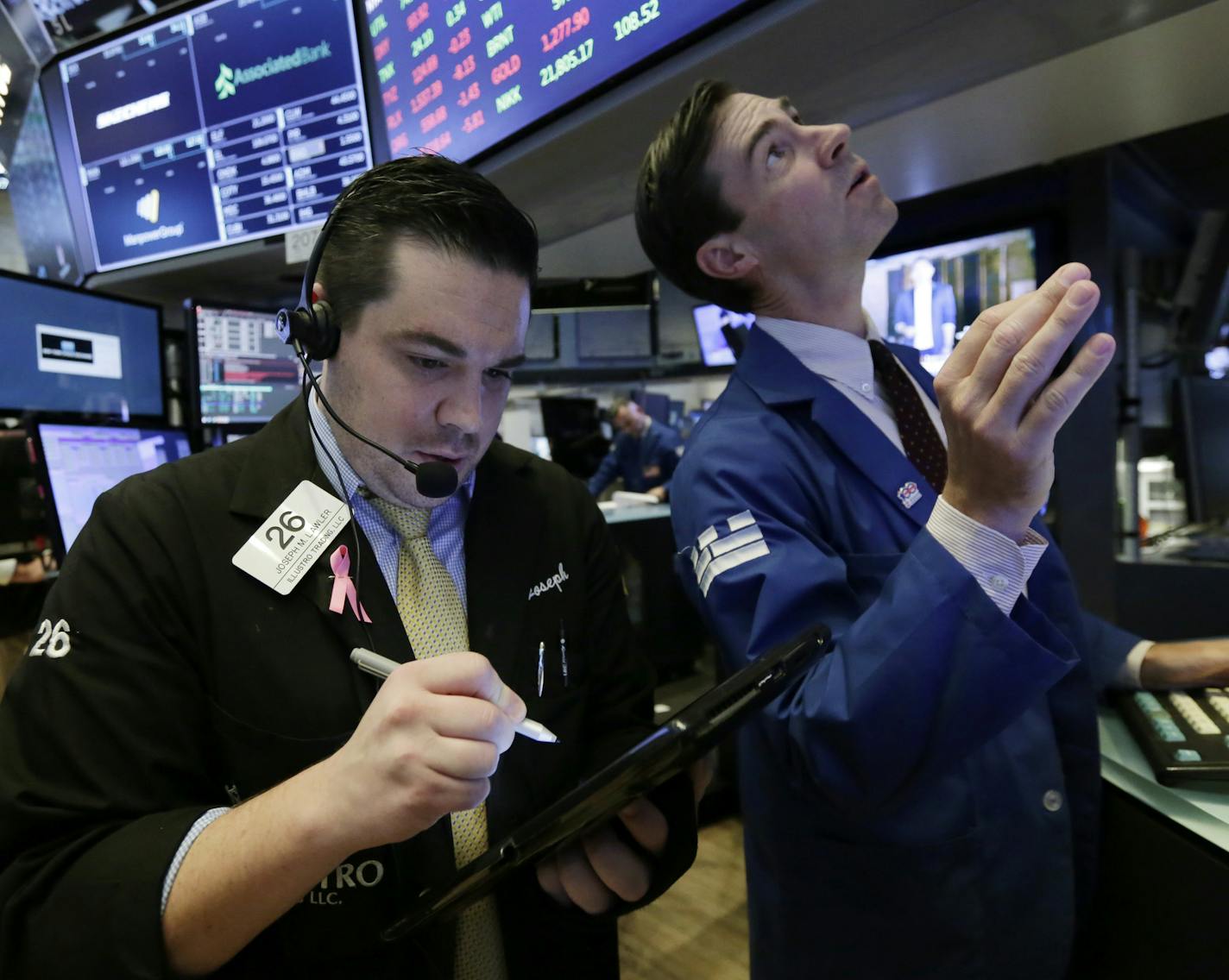 Trader Joseph Lawler, left, and specialist John McNierney work on the floor of the New York Stock Exchange, Tuesday, Oct. 24, 2017. U.S. stocks are edging higher Tuesday morning as construction equipment maker Caterpillar and Post-it note maker 3M lead a rally in industrial companies, while banks are climbing along with interest rates. (AP Photo/Richard Drew)