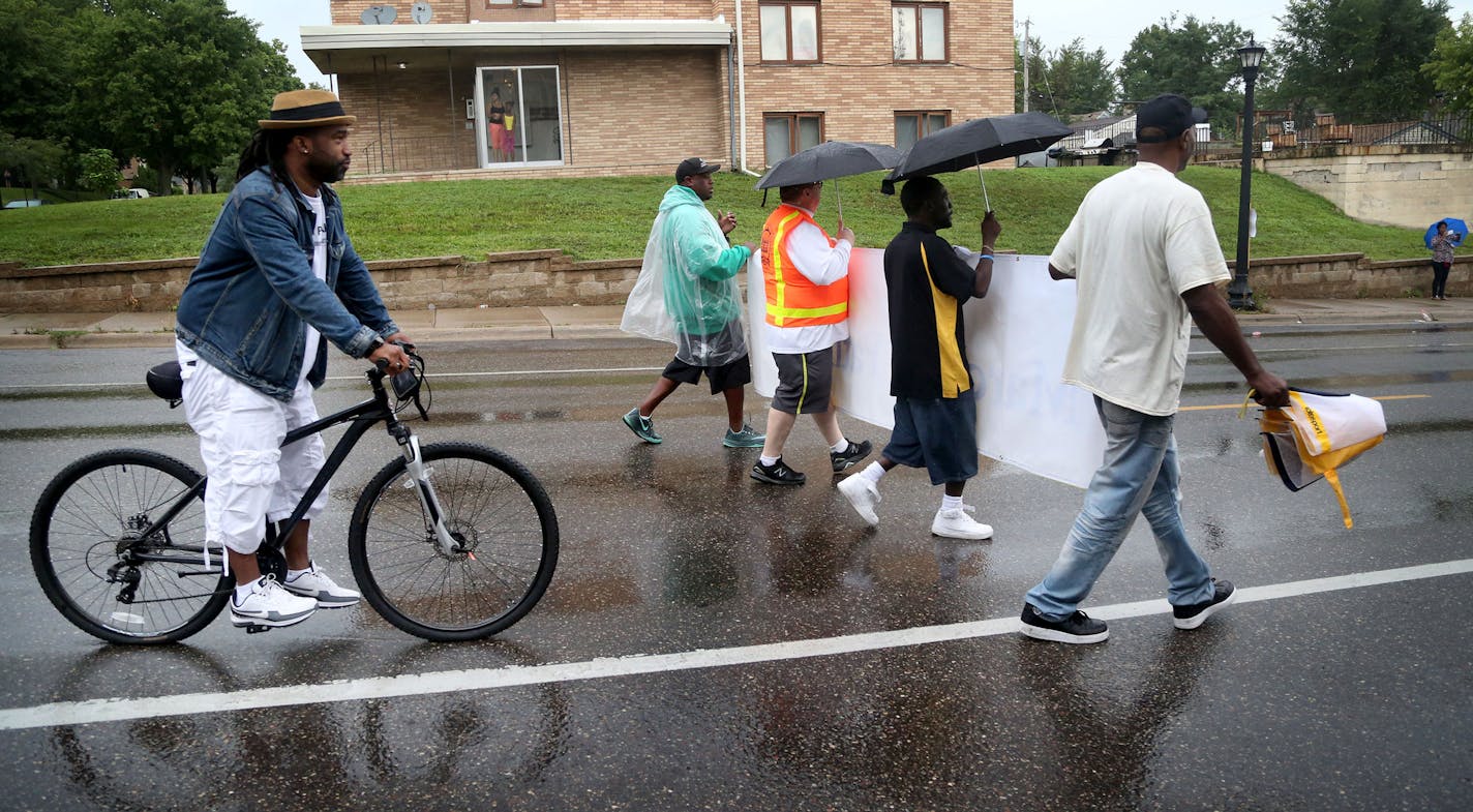 Guy Bowling of the Father Project, rear on bike, participated in a Family Day March of Fathers parade in 2016. He is one of 24 recipients of a Bush Foundation fellowship.