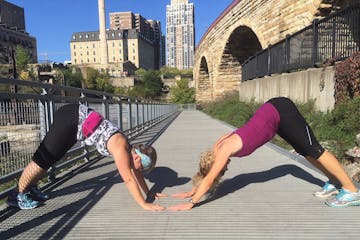 Leslie Branham and Valerie Neri held downward dog pose during last year's Surya Namaskar 5K in Minneapolis.