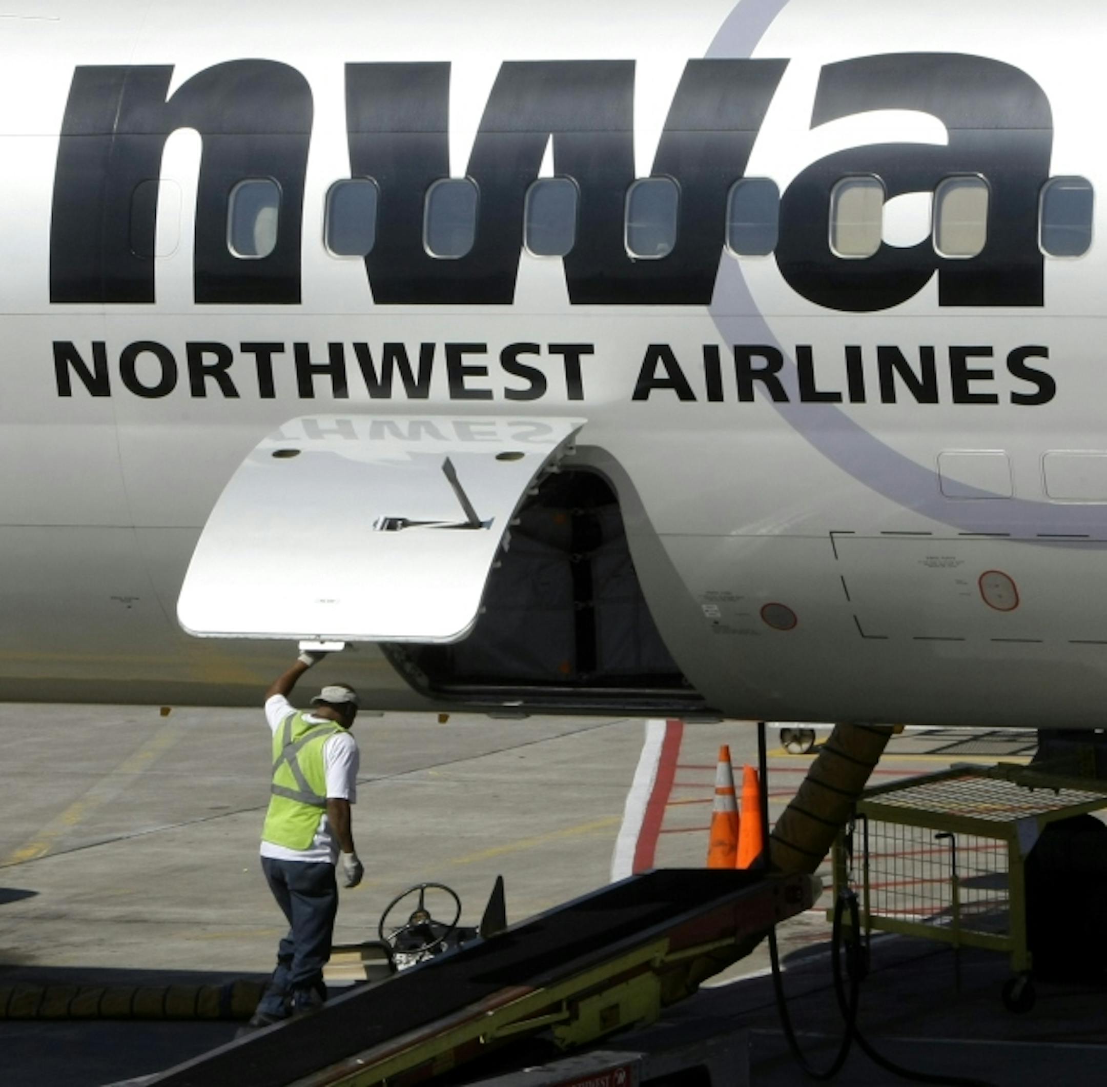 In this file photo from September 2008, a Northwest Airlines baggage handler closes the cargo door of a plane at the Minneapolis International Airport.