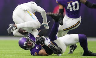 Los Angeles Chargers wide receiver Keenan Allen (13) is brought down by Minnesota Vikings safety Harrison Smith (22) in the third quarter of an NFL ga