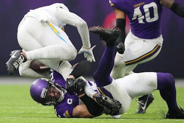 Los Angeles Chargers wide receiver Keenan Allen (13) is brought down by Minnesota Vikings safety Harrison Smith (22) in the third quarter of an NFL ga