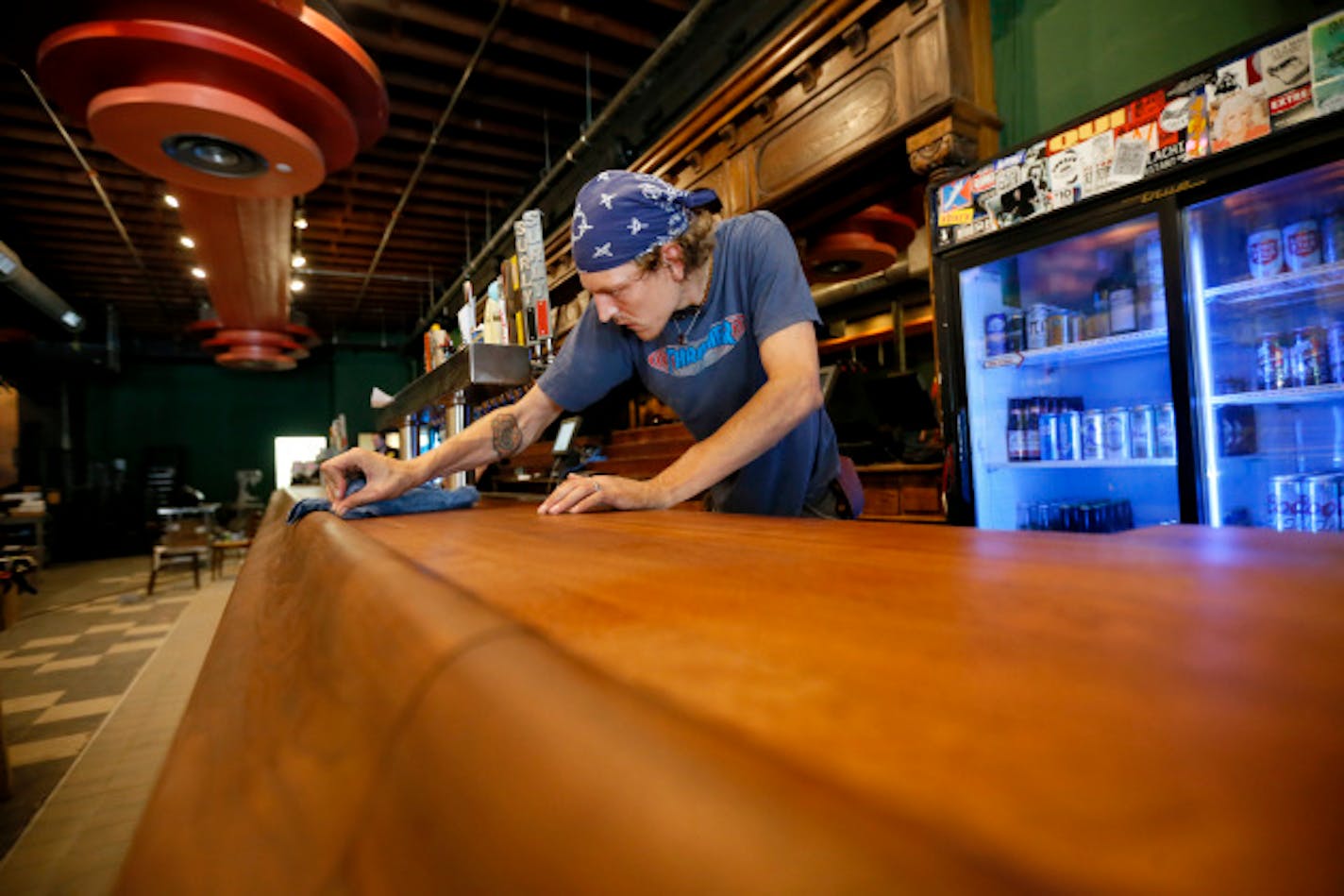 Daniel Hornfeldt wiped down the new bar top. / Jerry Holt, Star Tribune