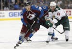Colorado Avalanche right wing Ben Smith, front, looks to pass the puck as Minnesota Wild forward Tyler Graovac defends in the third period of an NHL p