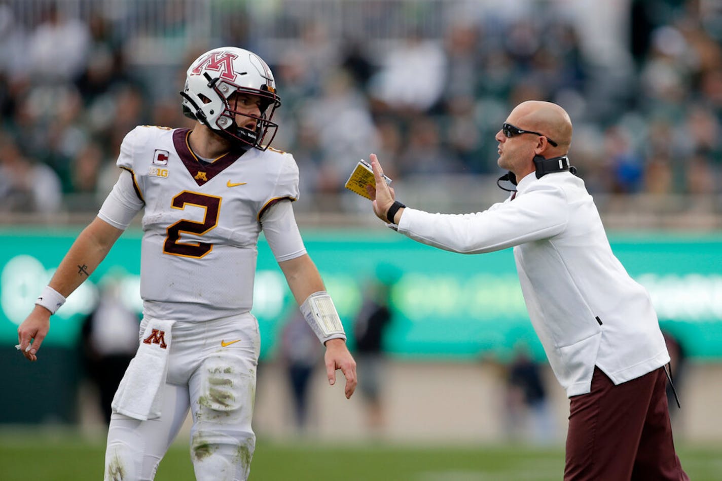 Minnesota coach P.J. Fleck, right, talks with quarterback Tanner Morgan during Saturday's 34-7 rout of Michigan State.