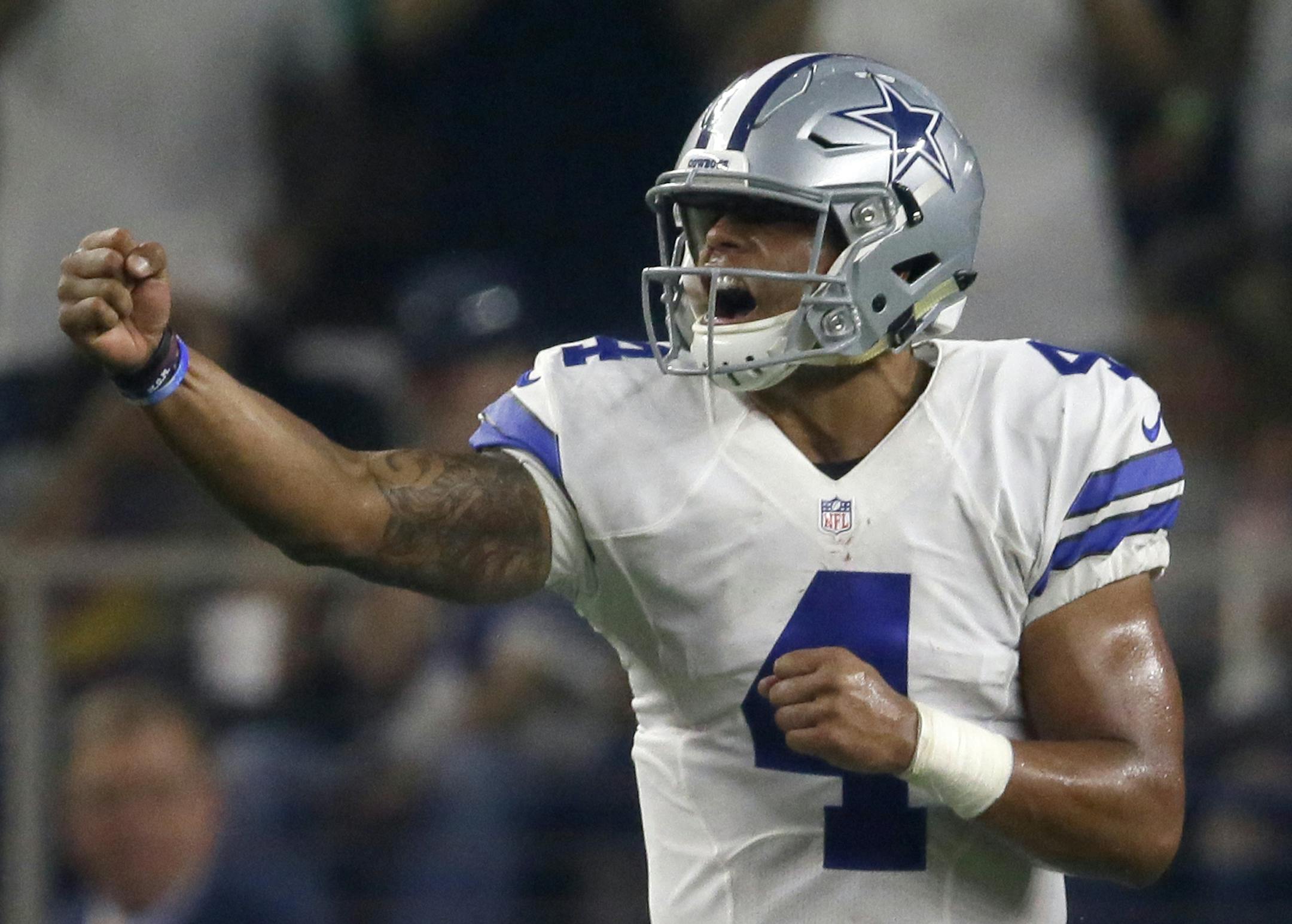 Dallas Cowboys quarterback Dak Prescott (4) celebrates a touchdown scored by running back Lance Dunbar on a running play against the Chicago Bears in the first half of an NFL football game, Sunday, Sept. 25, 2016, in Arlington, Texas. (AP Photo/LM Otero)