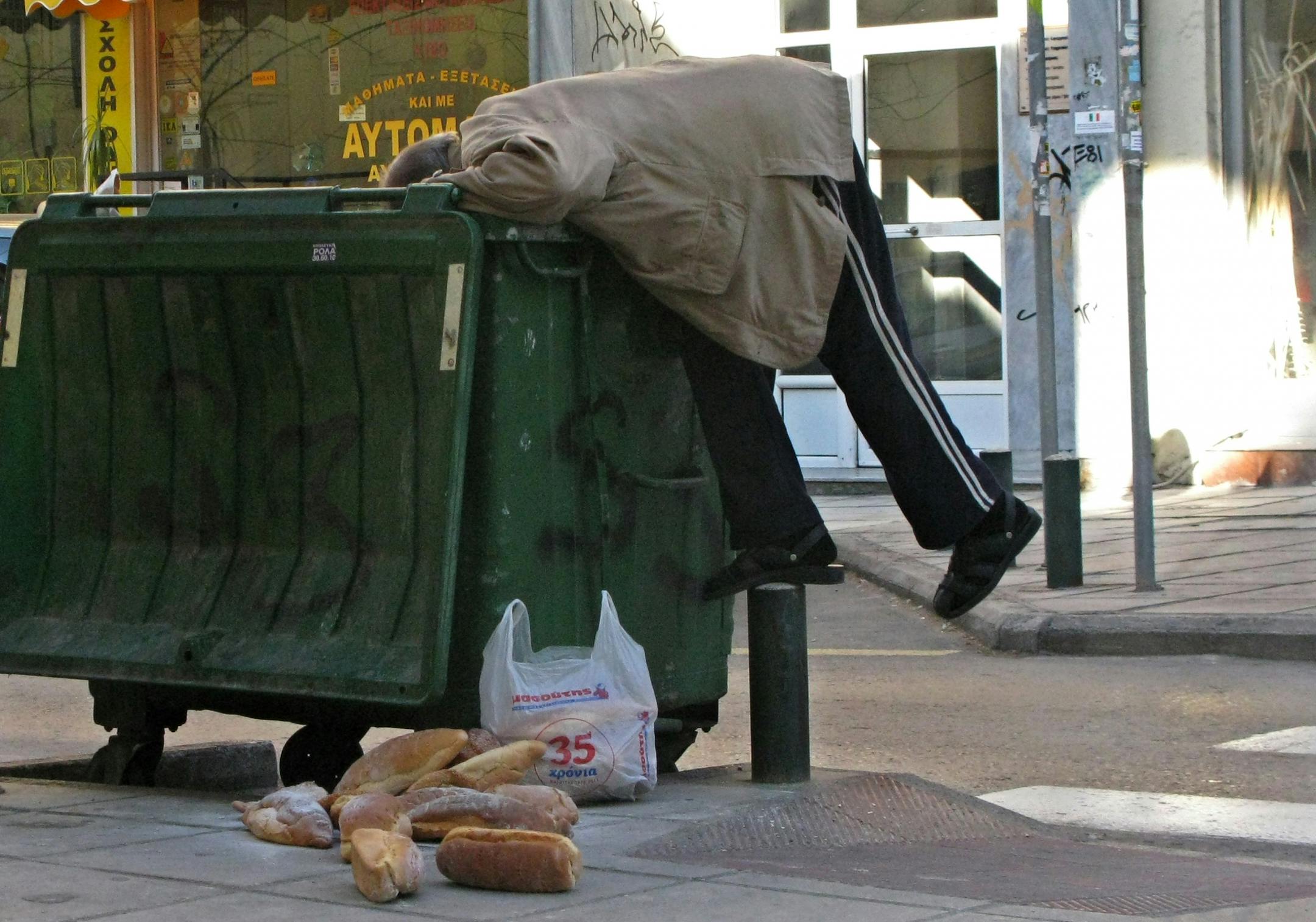 A man collects bread from a trash bin in the northern port city of Thessaloniki, Greece, Wednesday, Jan. 4, 2012. Welfare agencies and charity groups have warned of a spike in poverty and homelessness in Greece due to the effects of the financial crisis.