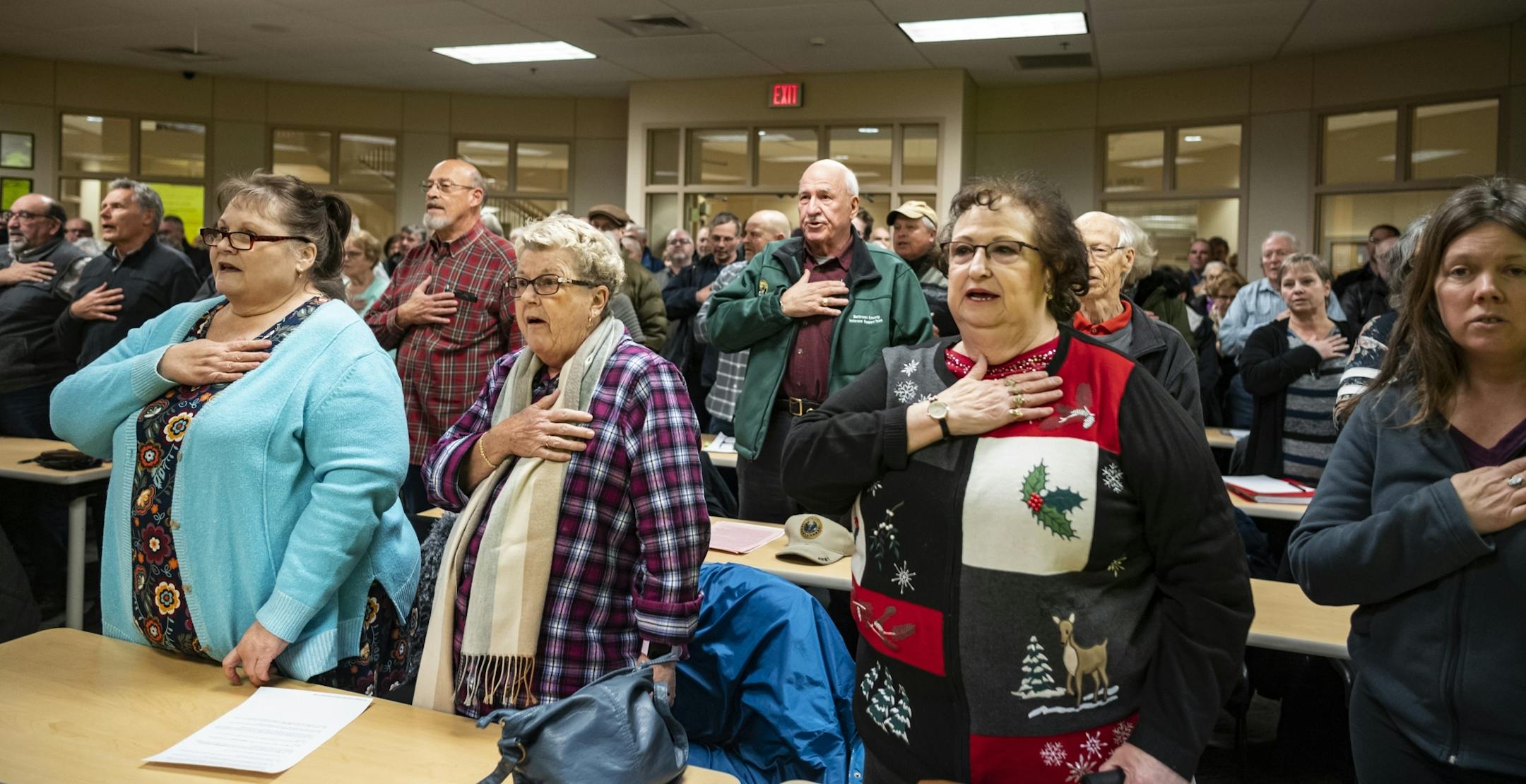 Attendees stood up to say the Pledge of Allegiance before the meeting got underway.