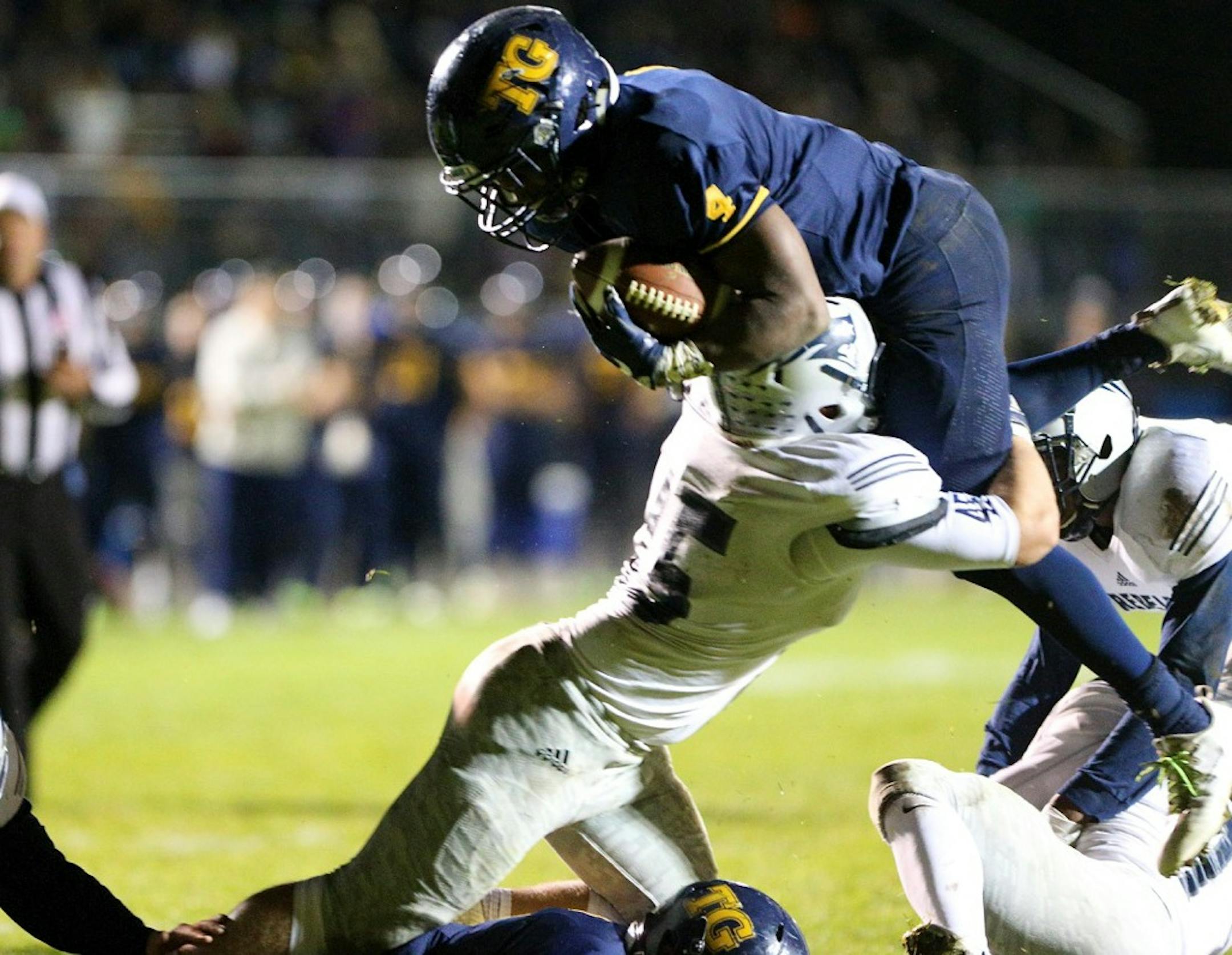 Totino Grace running back Gayflor Flomo leaps over a Champlin Park defender to score for Eagles in their victory over Champlin Park on Friday.
