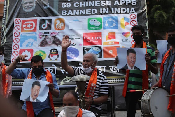 FILE- Activists of Jammu and Kashmir Dogra Front shout slogans against Chinese President Xi Jinping next to a banner showing the logos of TikTok and o