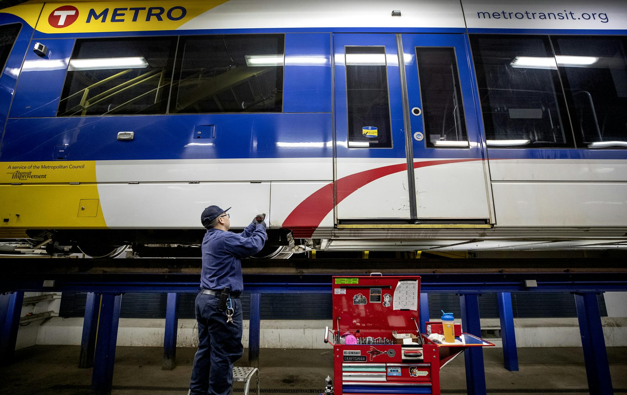 Chee Vang worked on a Metro Transit light-rail train at the St. Paul facility. Vang recently graduated from a two-year program at Hennepin Tech and now is working as an LRT technician. ] CARLOS GONZALEZ • cgonzalez@startribune.com – St. Paul, MN – August 14, 2019, Metro Transit has deployed a unique program to develop light-rail train technicians and has hired the first six graduates to make it through the intensive training program. Chee Vang recently graduated from a two-y