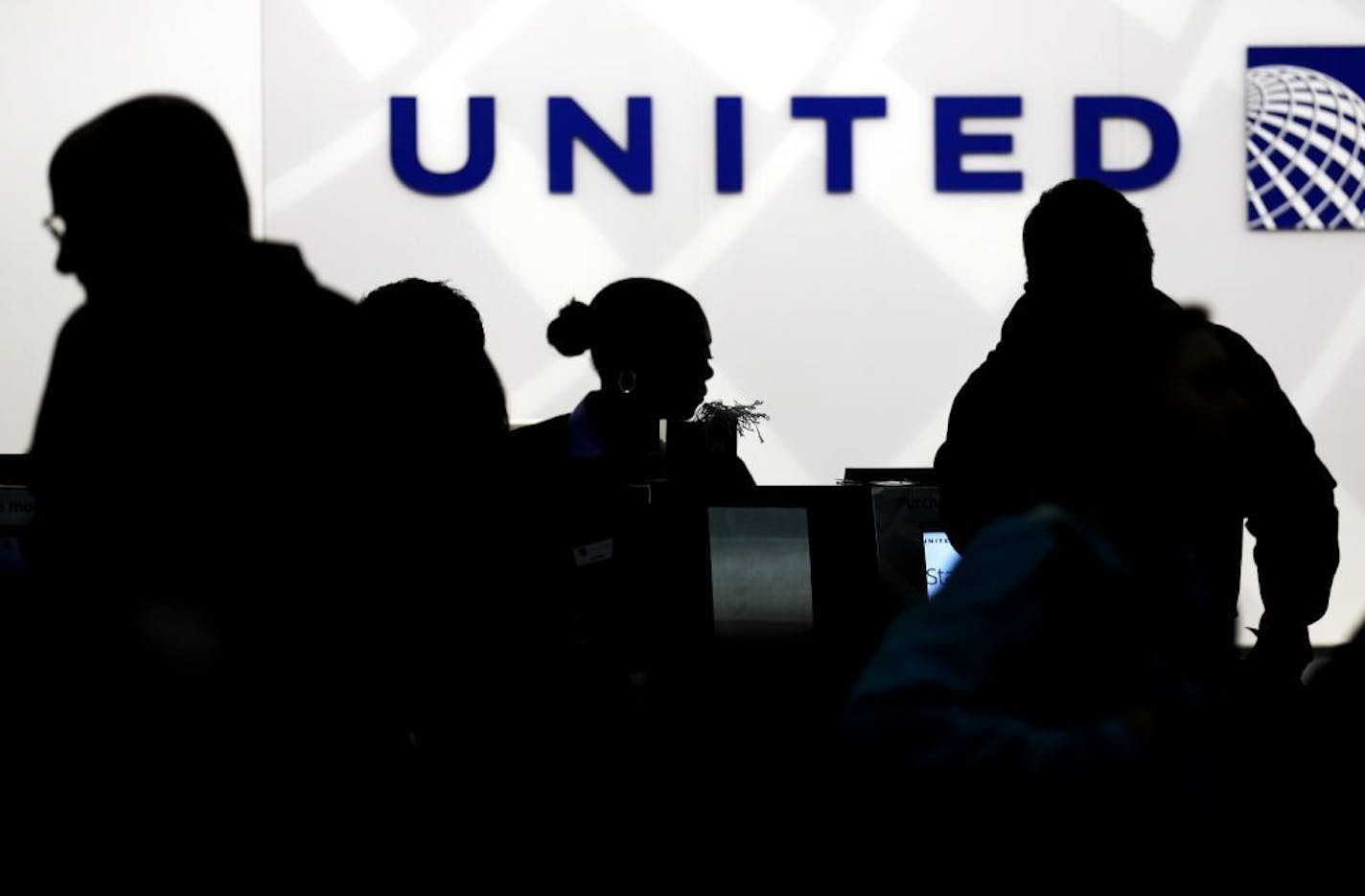 FILE - In this Saturday, Dec. 21, 2013, file photo, travelers check in at the United Airlines ticket counter at Terminal 1 in O'Hare International Airport in Chicago. After a man is dragged off a United Express flight on Sunday, April 9, 2017, United Airlines becomes the butt of jokes online and on late-night TV. Travel and public-relations experts say United has fumbled the situation from the start, but it�s impossible to know if the damage is temporary or lasting. Air travelers are drawn to th