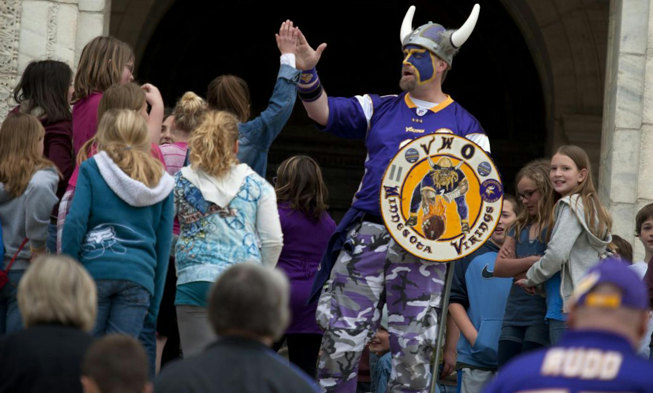 Vikings World Order member Scott Asplund who goes by "Skolt" high-fived school kids at the top of the Capitol steps Monday.