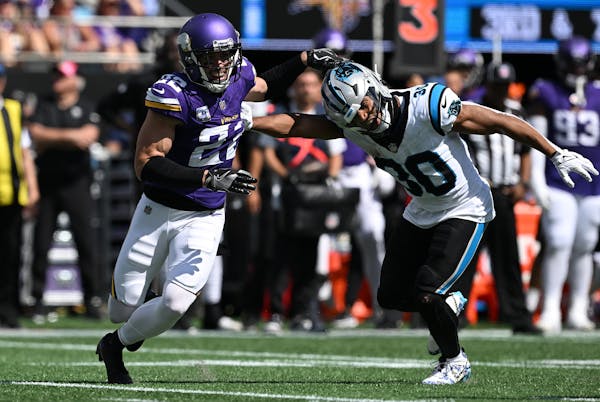 Harrison Smith (22) of the Minnesota Vikings pass rushes against Chuba Hubbard (30) in the second quarter.