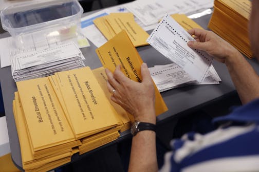 Hundreds of volunteers and election officials started the absentee ballot count this week for all of the Hennepin County cities, except Minneapolis, in downtown Minneapolis. Scott Soukup took ballots out the the enclosed envelops as one of the steps in the count.