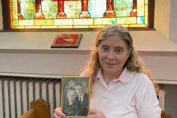 Patti-Folstad Bouley, holding a photo of her great-grandparents in frontt of a stained-glass window honoring their parents.Curt Brown