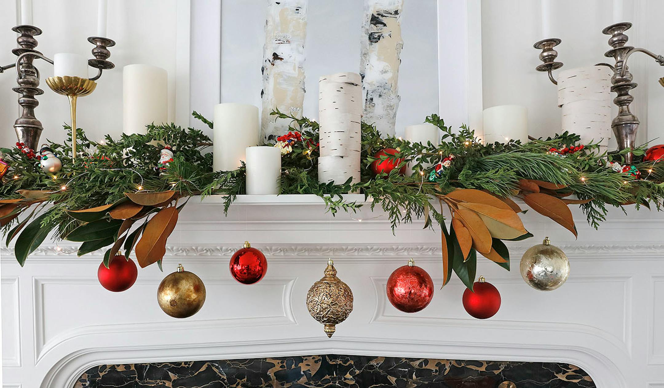 Merry mantel: Pick out a few ornaments with a common quality, such as shiny glass. Layer sprigs of fresh greens- cypress, oregonia - and brown magnolia branches, and tuck in in red berry picks. Tie the ornaments with invisible fishing line to the greens. Place birch sculptures or candleholders. Use white pillar candles, which contrast the evergreen, but don't compete with the colorful ornaments. Place gold and silver candleholders of different heights and shapes. Loosely weave a string of batter