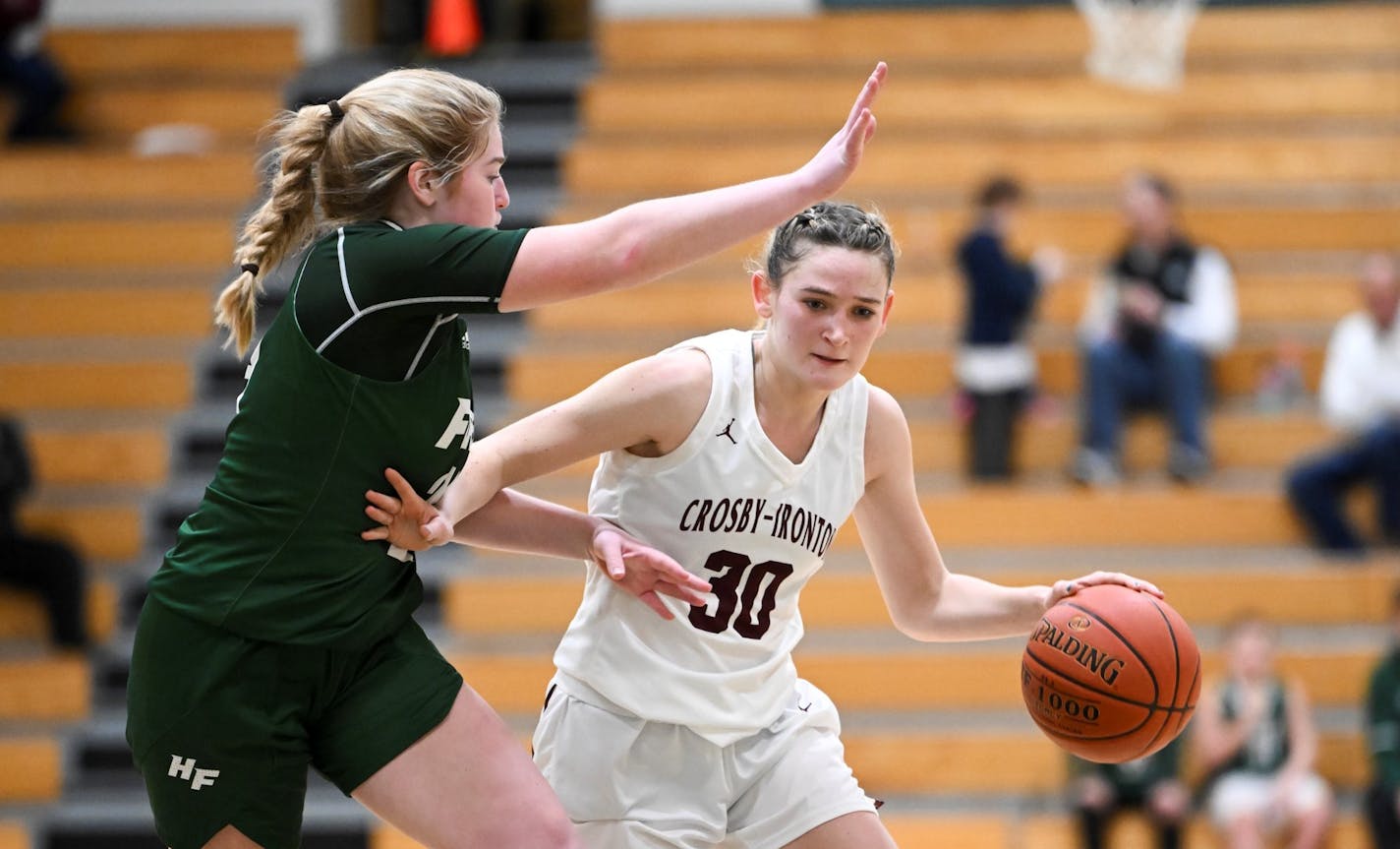 Crosby-Ironton's Tori Oehrlein dribbles toward the basket against Holy Family's Sophia Zay Saturday, Feb. 4, 2023 at Holy Family High School in Victoria, Minn. Oehrlein is one of two girls racing to be the first 9th grader to score 2,000 points in state history. She tacked on 36 more points during Saturday's game, despite losing to Holy Family 66-53 ] AARON LAVINSKY • aaron.lavinsky@startribune.com