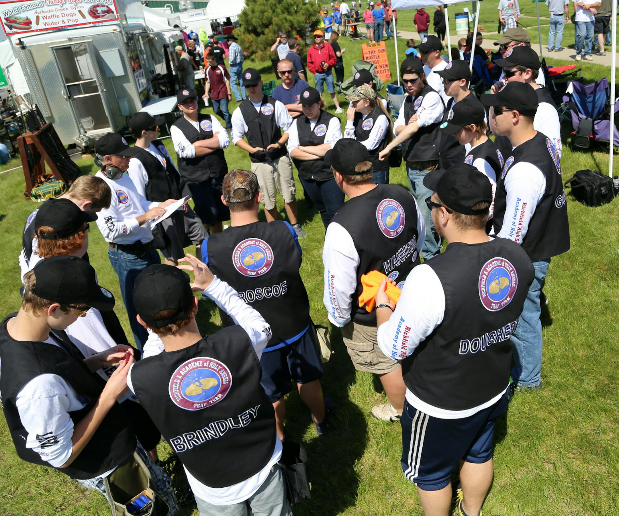 The combined clay target shooting team from Richfield High School and the Academy of Holy Angels discusses strategy prior to shooting in Alexandria, Minn., Friday at the Minnesota State High School Clay Target League Championship.