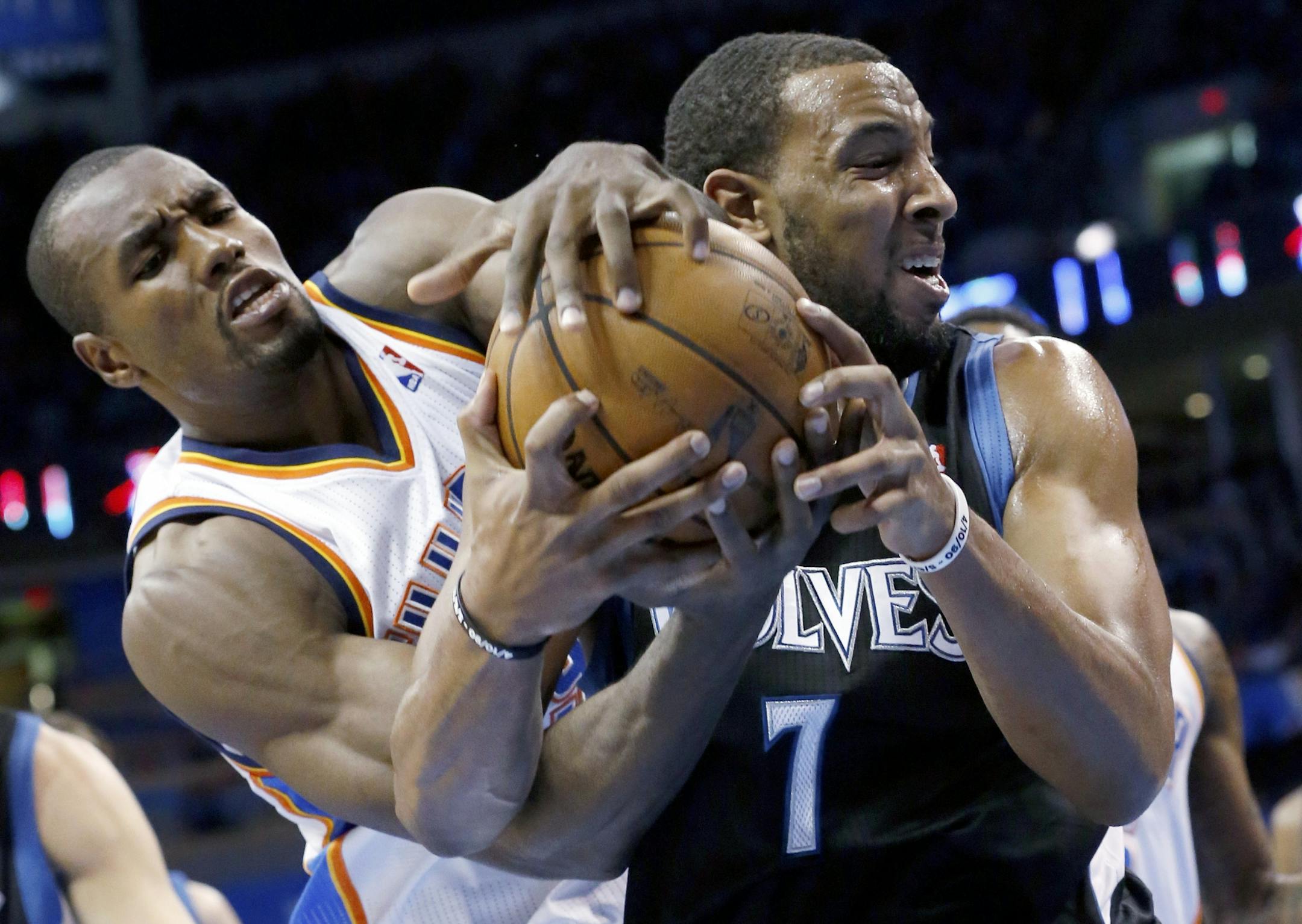 Oklahoma City forward Serge Ibaka and Timberwolves forward Derrick Williams fight for control of the ball.