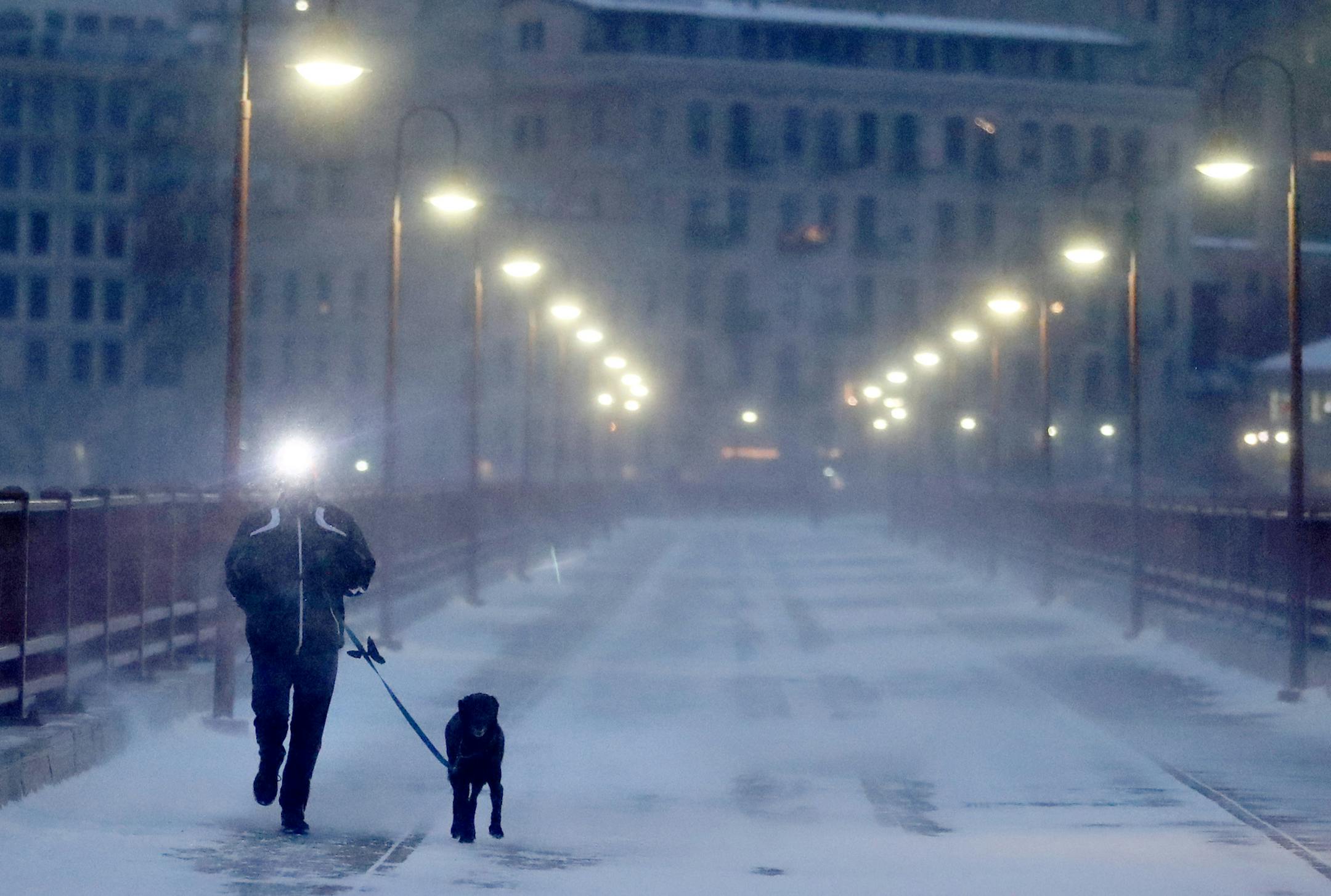 A runner and his dog brave frigid conditions while making their way east across the Stone Arch Bridge Thursday, Jan. 24, 2019, in Minneapolis, MN.] DAVID JOLES • david.joles@startribune.com Blast of Arctic air