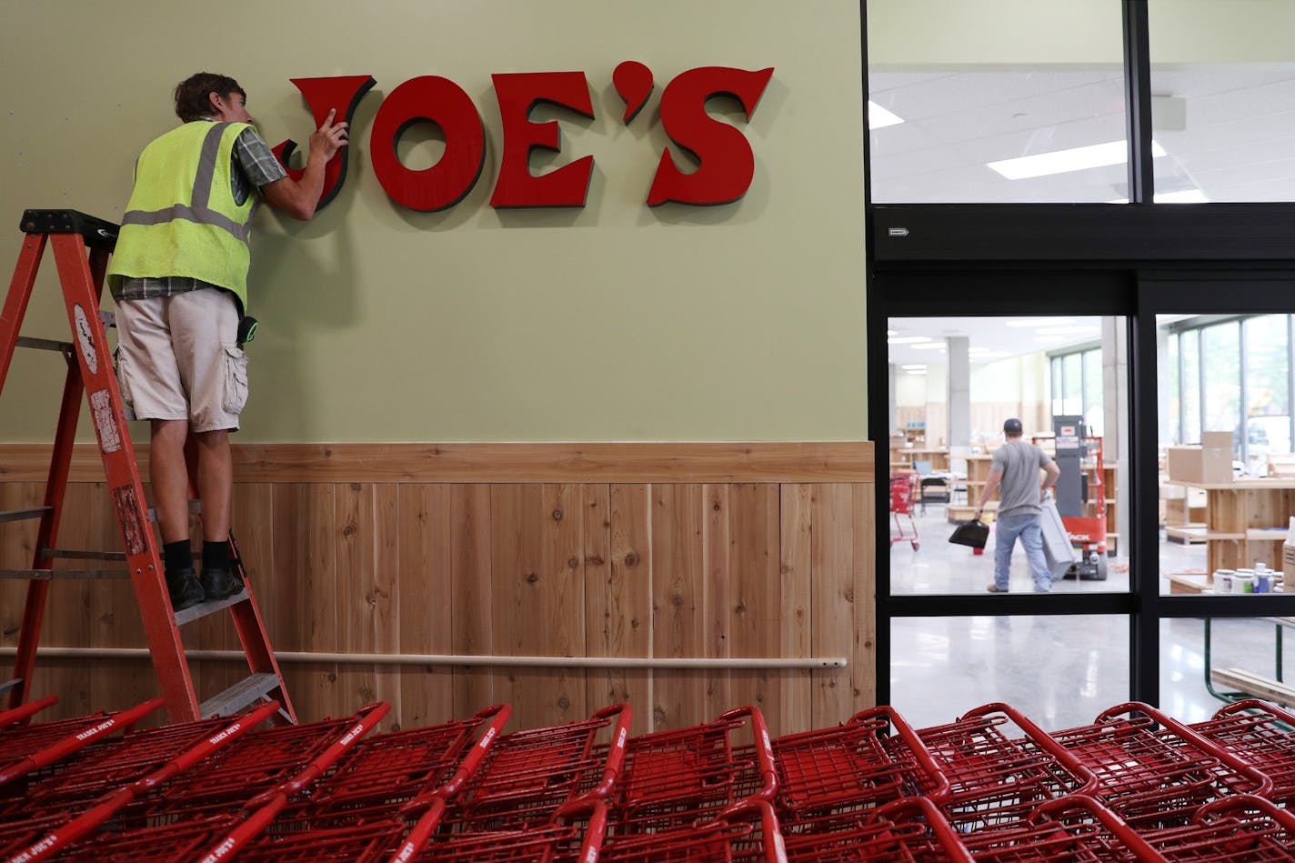 Jacob Meister, an installer with Electro Signs, put the J on the Trader Joe's sign at the store on Washington Avenue South as he and others prepared for its opening next month. ] ANTHONY SOUFFLE &#xef; anthony.souffle@startribune.com Crews worked to ready the Trader Joe's store on Washington Avenue South for its opening next month Tuesday, June 26, 2018 in Minneapolis.